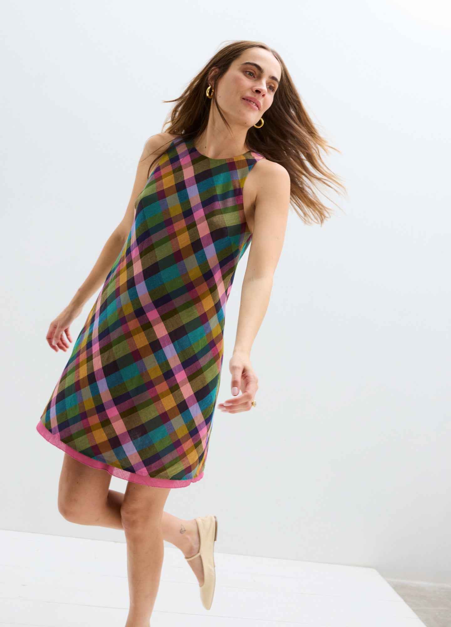 Colorful plaid sleeveless mini maternity dress with an A-line silhouette and round neckline.