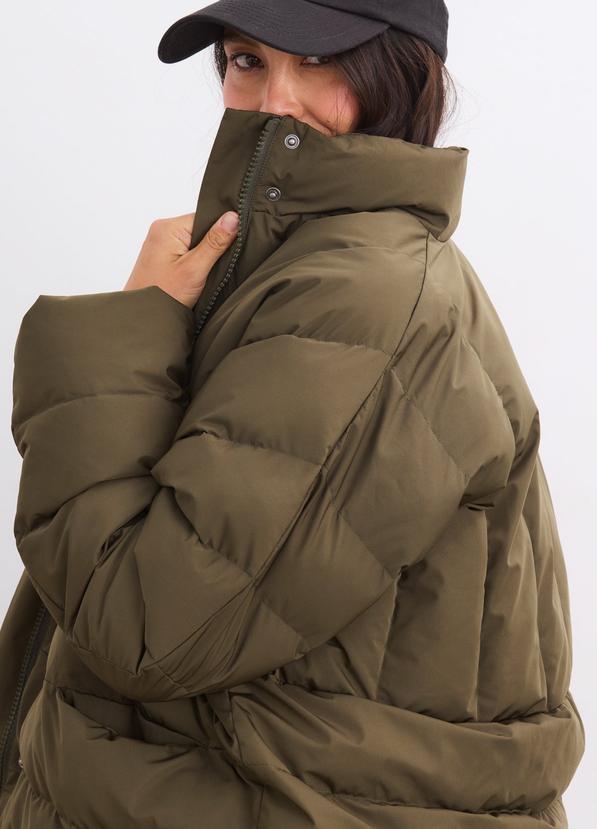 Olive green padded maternity puffer jacket with high collar and quilted design.