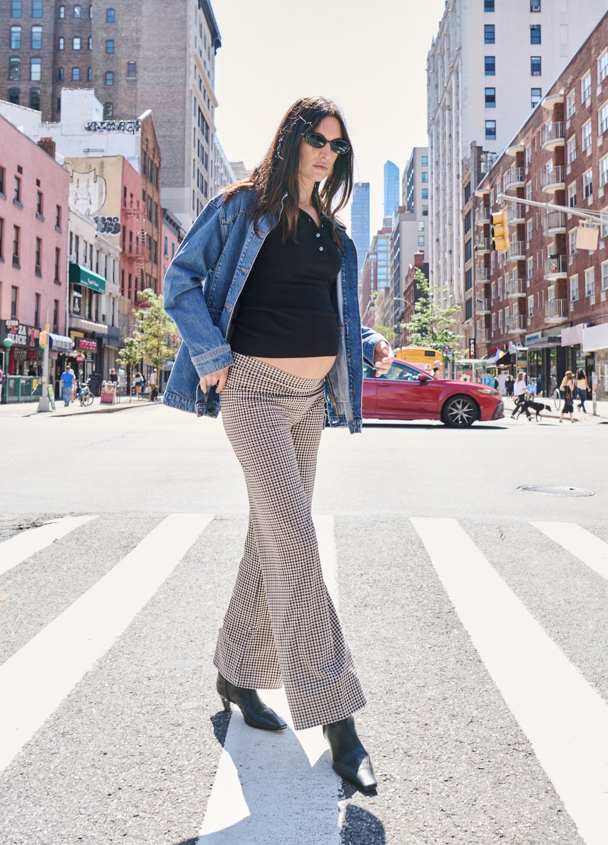 Beige maternity pants with a stretchy waist and flared legs, styled with a black top and blue denim jacket.