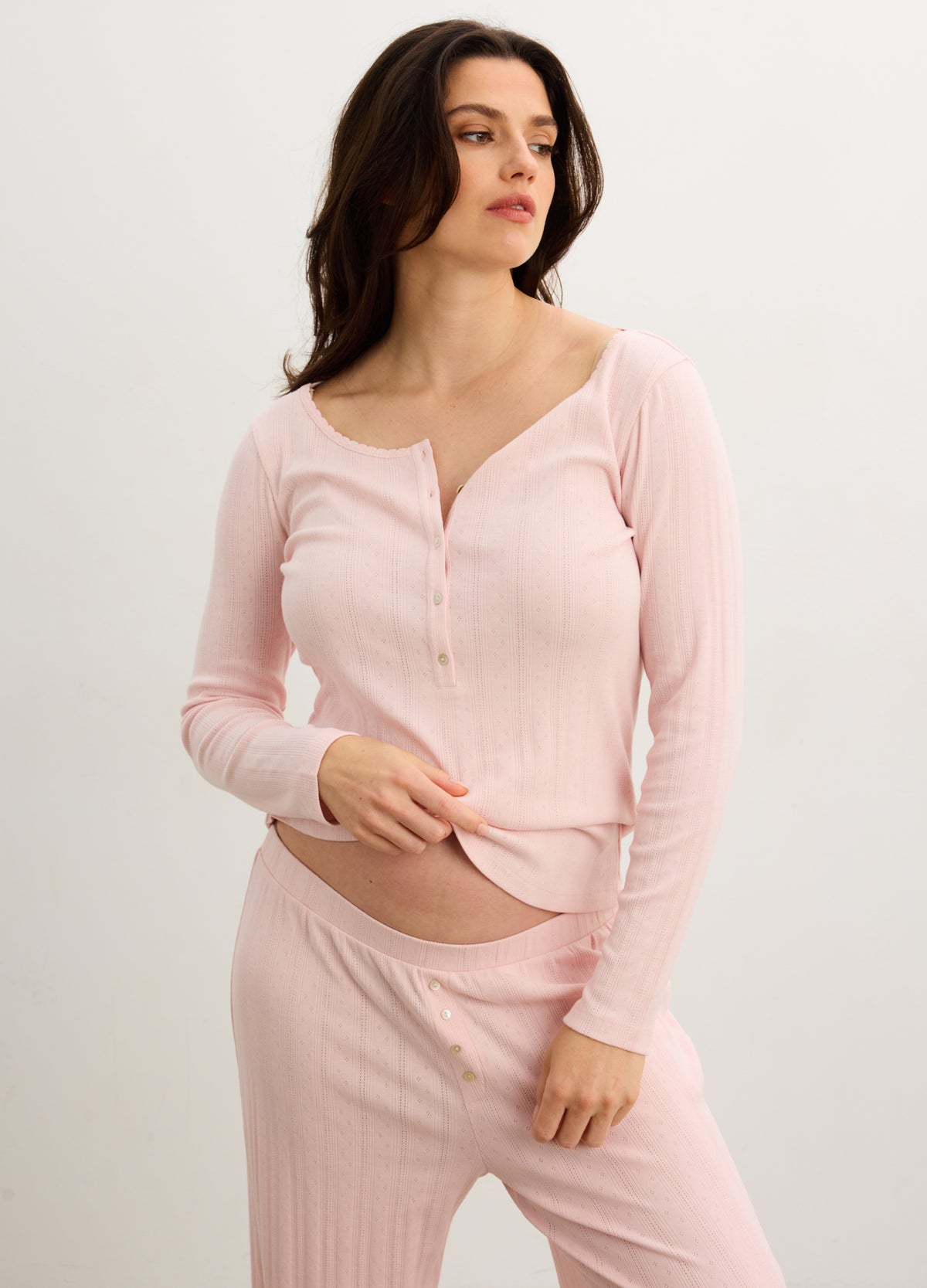 Soft pink ribbed long sleeve maternity henley top with button front and scoop neckline.