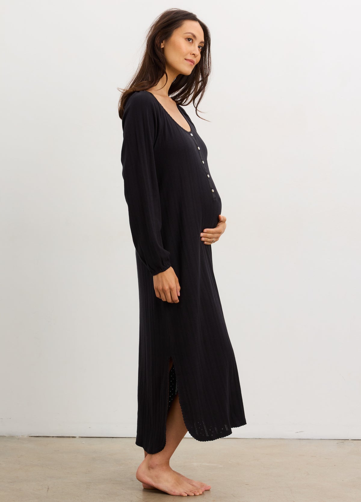Black long sleeve maternity nightgown with button front and ribbed knit fabric, midi length with side slits.