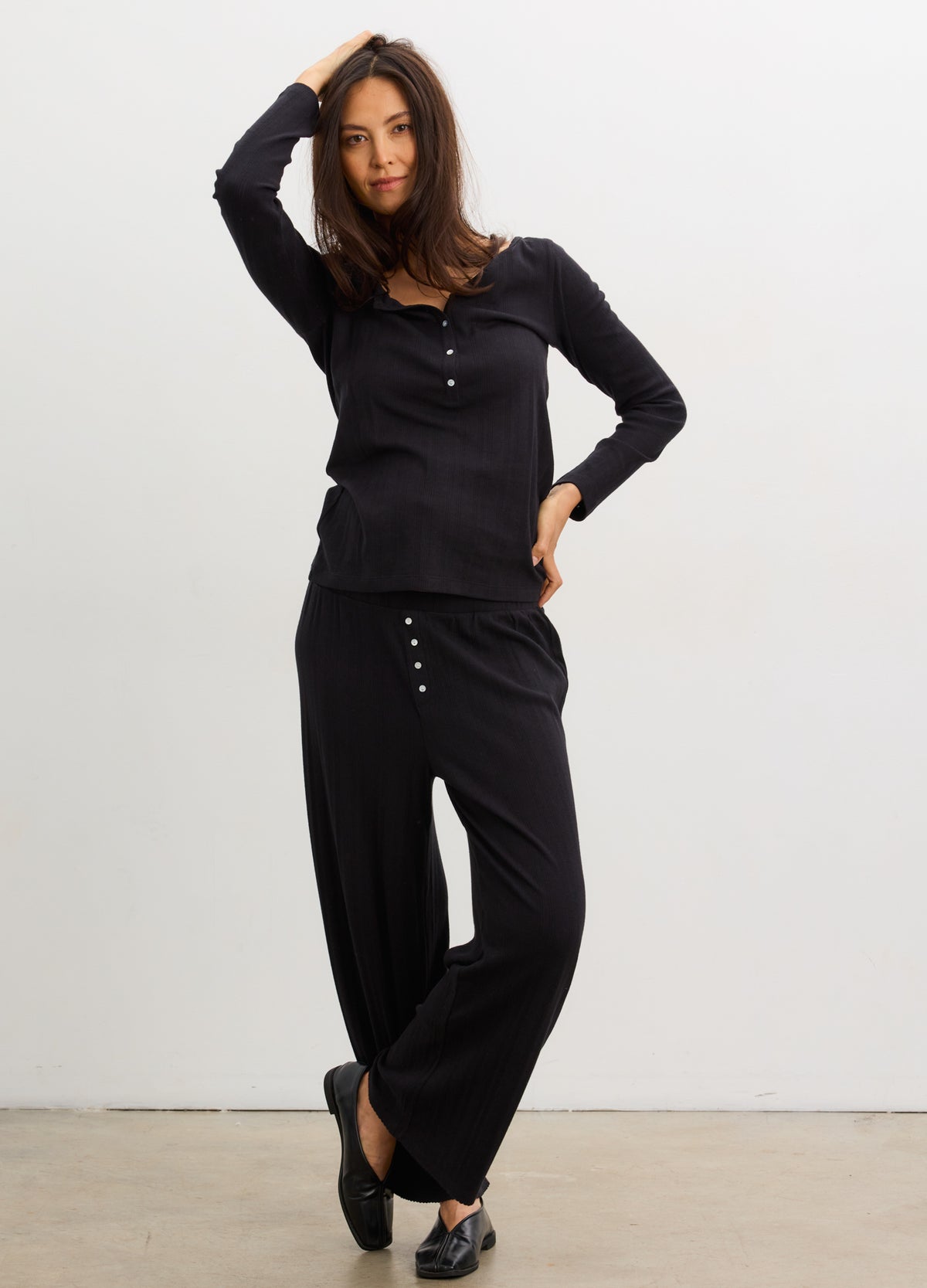 Black maternity pointelle pants with button details, worn by pregnant model in relaxed fit.