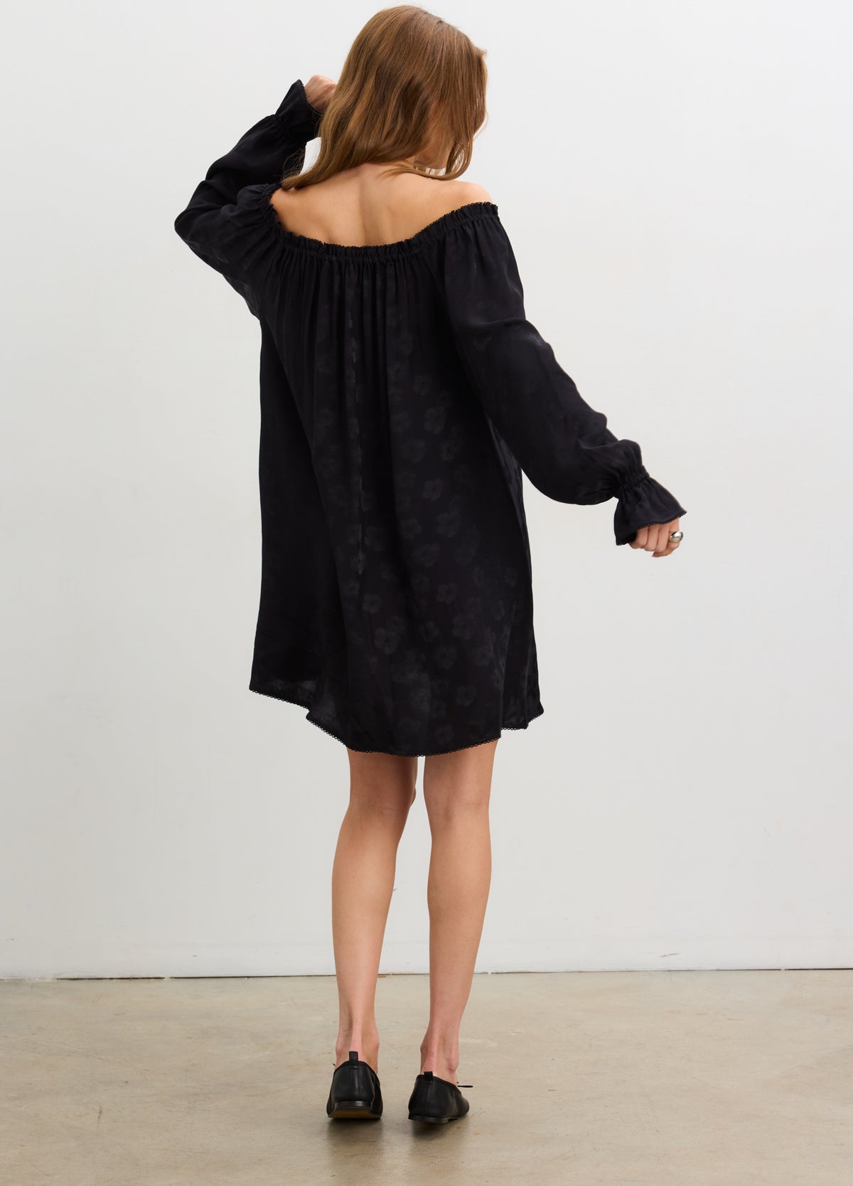 Black off-the-shoulder jacquard mini dress with long balloon sleeves, designed for pregnant maternity wear.
