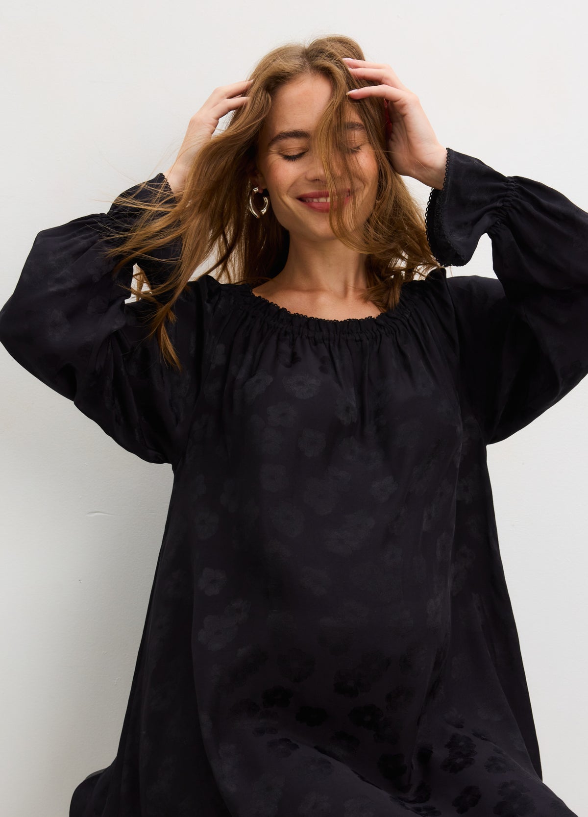 Black off-the-shoulder jacquard mini dress with long puff sleeves, designed for maternity and pregnant wear.