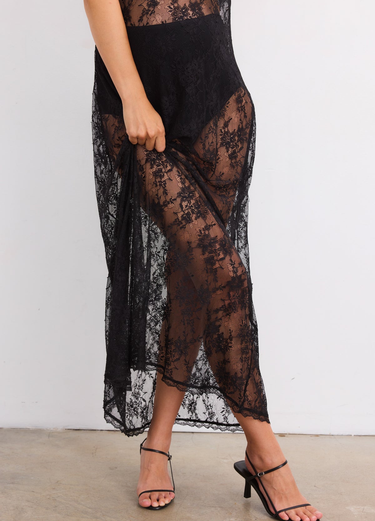 Black sheer lace maternity dress with floral pattern, fitted waist and ankle-length hem.
