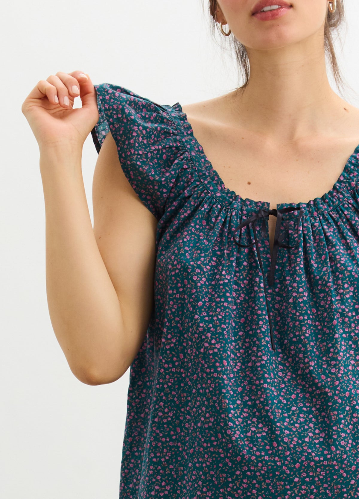 Sleeveless maternity tank with ruffled shoulder in dark blue floral print, designed for pregnant comfort.