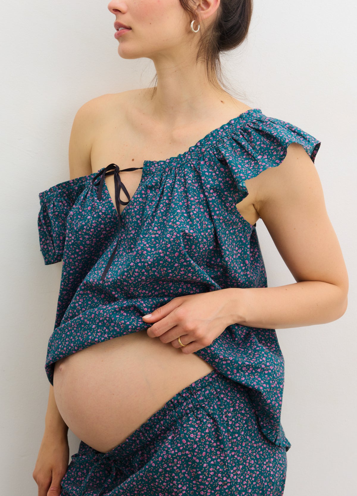 Maternity ruffle tank top in blue with small floral print, designed for pregnant women with adjustable one-shoulder detail.