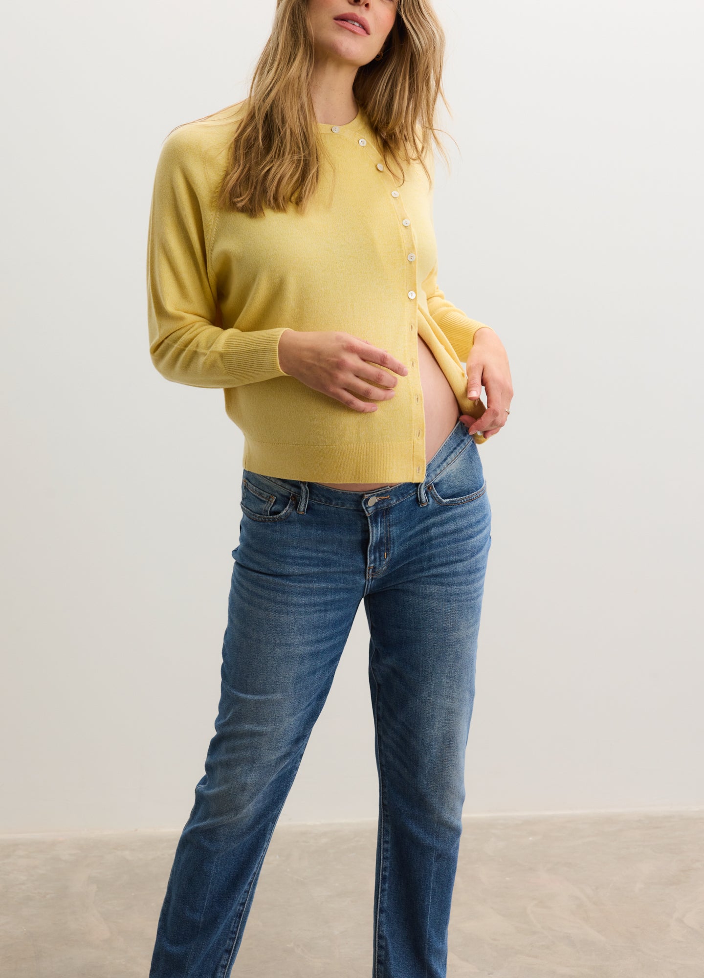 Soft yellow maternity cardigan with long sleeves and button front, styled open over bump-friendly top.