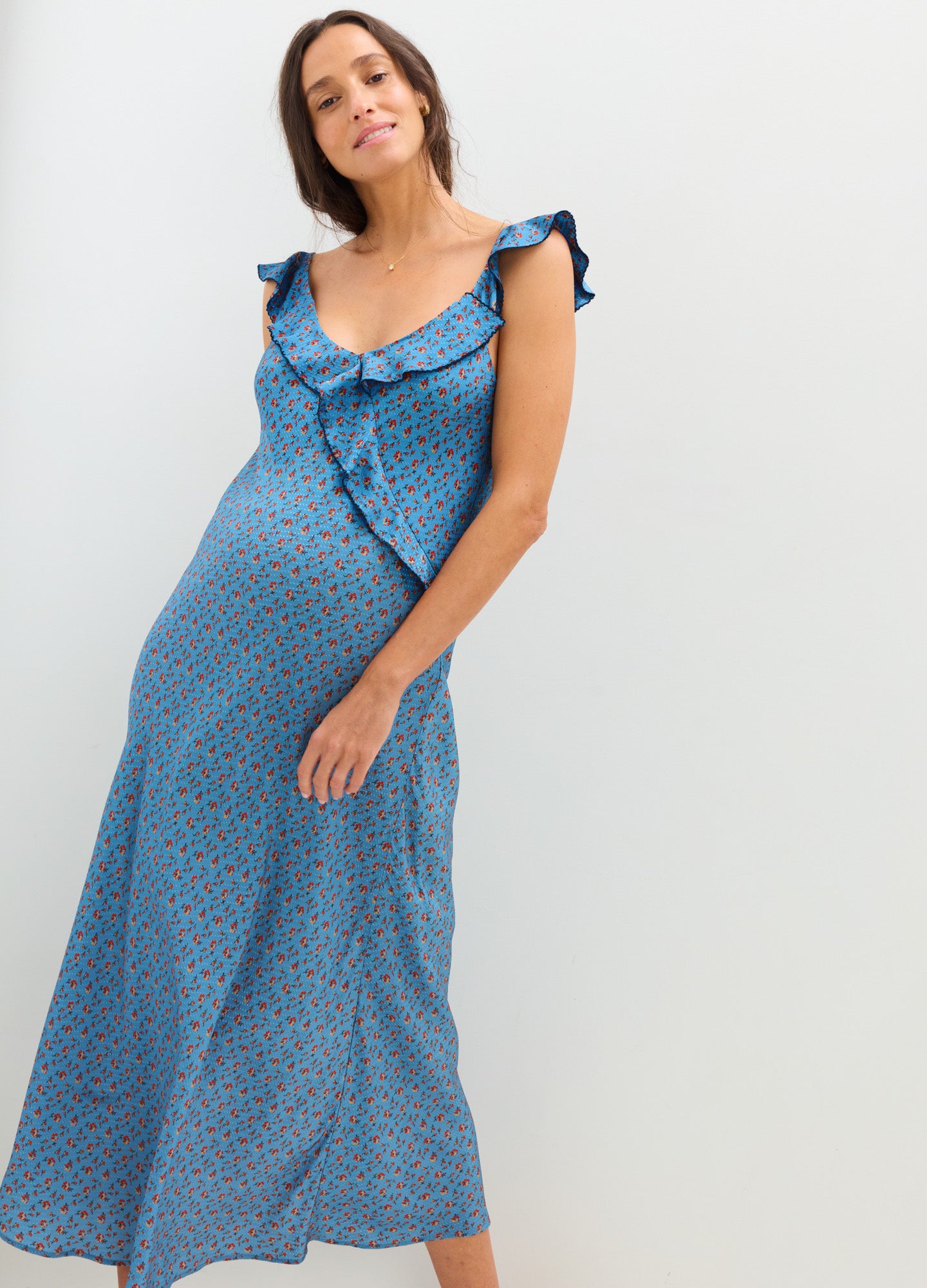 Blue midi maternity dress with small floral print, ruffled cap sleeves, and sweetheart neckline.
