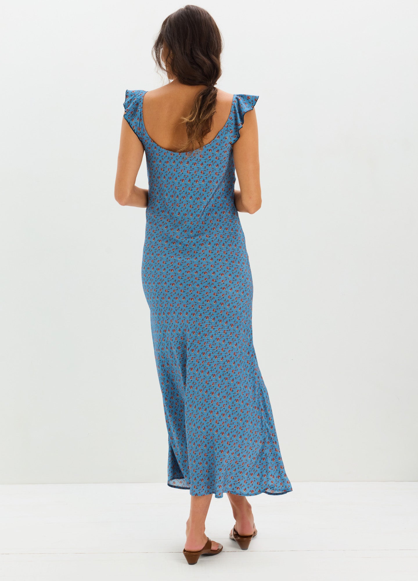 Blue midi maternity dress with small floral print, flutter sleeves, and a scoop back.