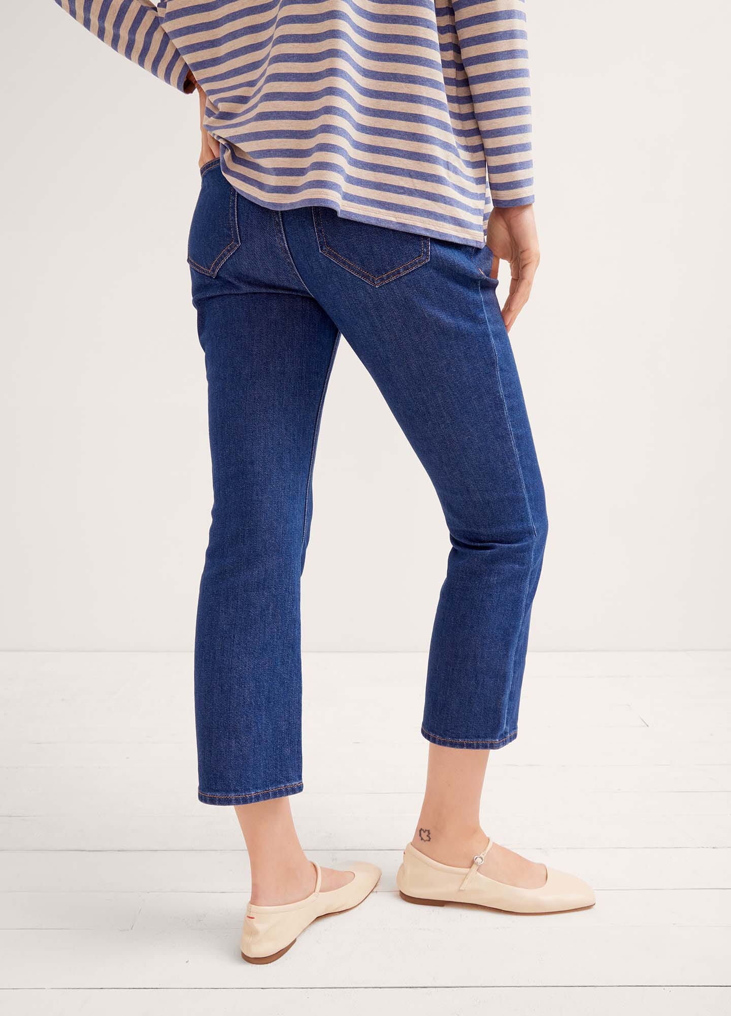 Dark blue denim maternity jeans with over-the-bump stretchy panel and cropped straight legs.