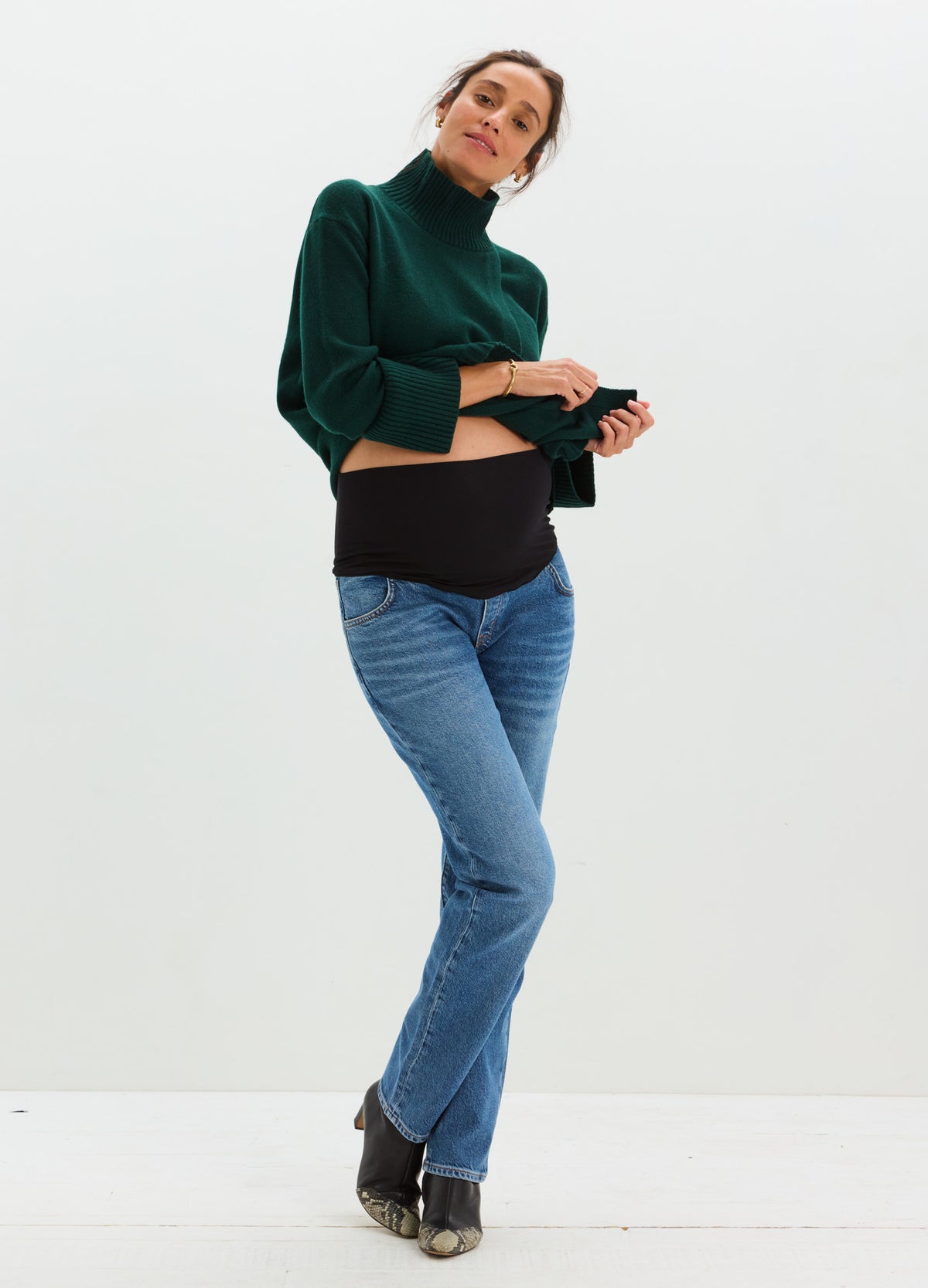 Light blue straight-leg maternity jeans with over-the-bump black elastic panel worn by pregnant model.