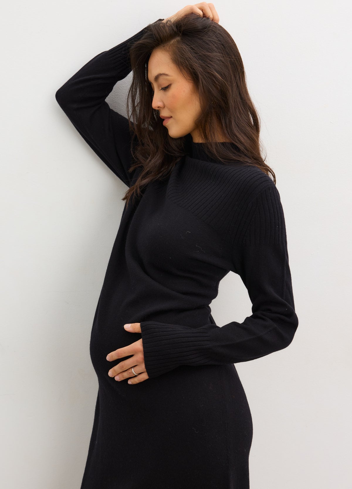 Black mockneck maternity sweater dress with long sleeves and a fitted silhouette.