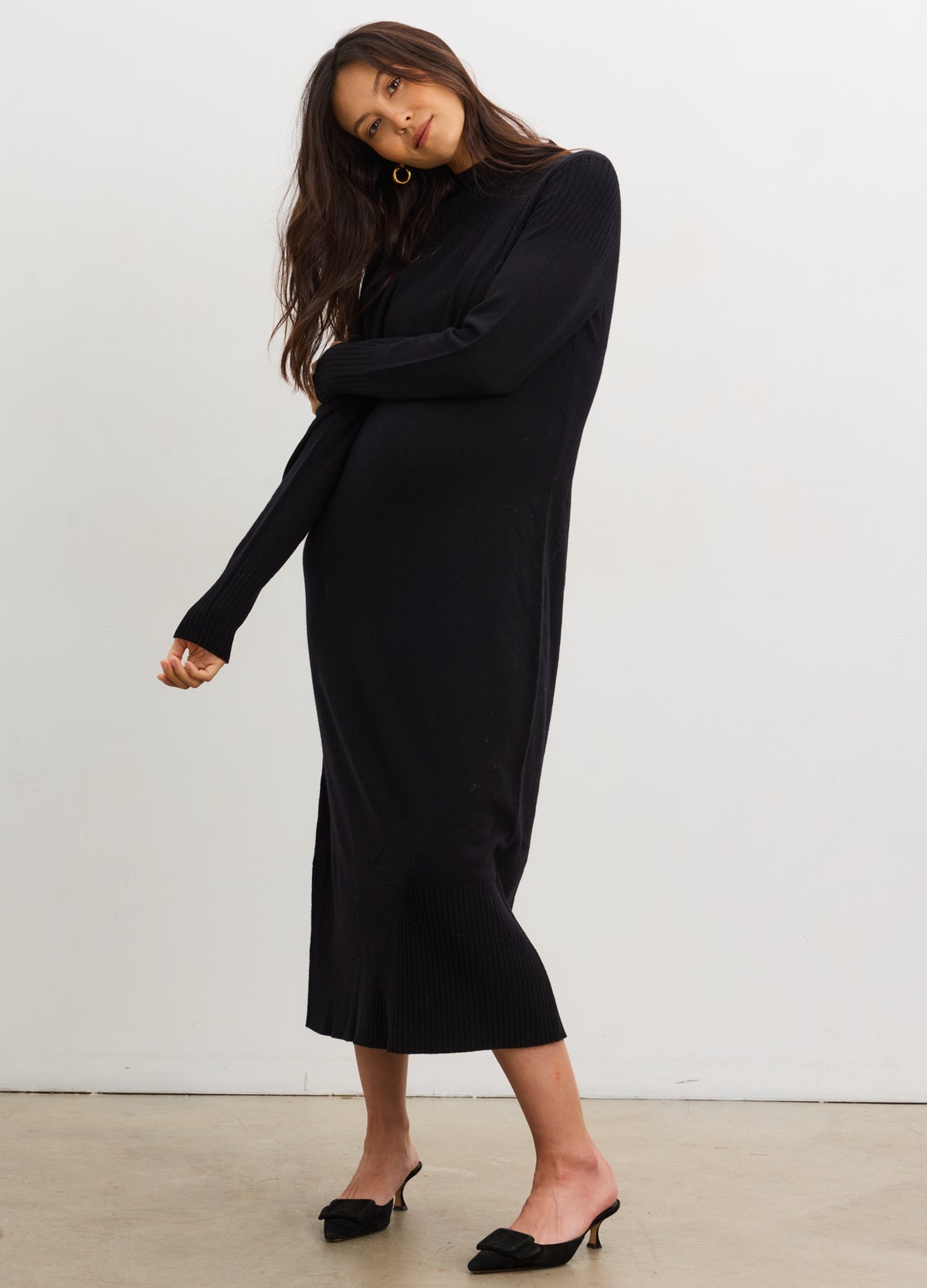 Black maternity mockneck sweater dress with long sleeves and relaxed fit, styled on pregnant model.