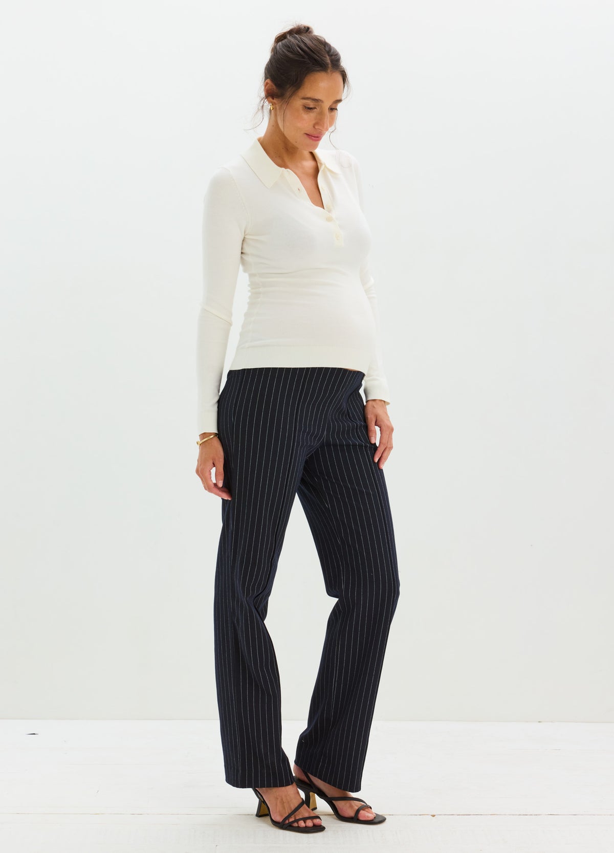 Black pinstripe maternity work pants with seamed detailing, straight-leg fit on pregnant model.