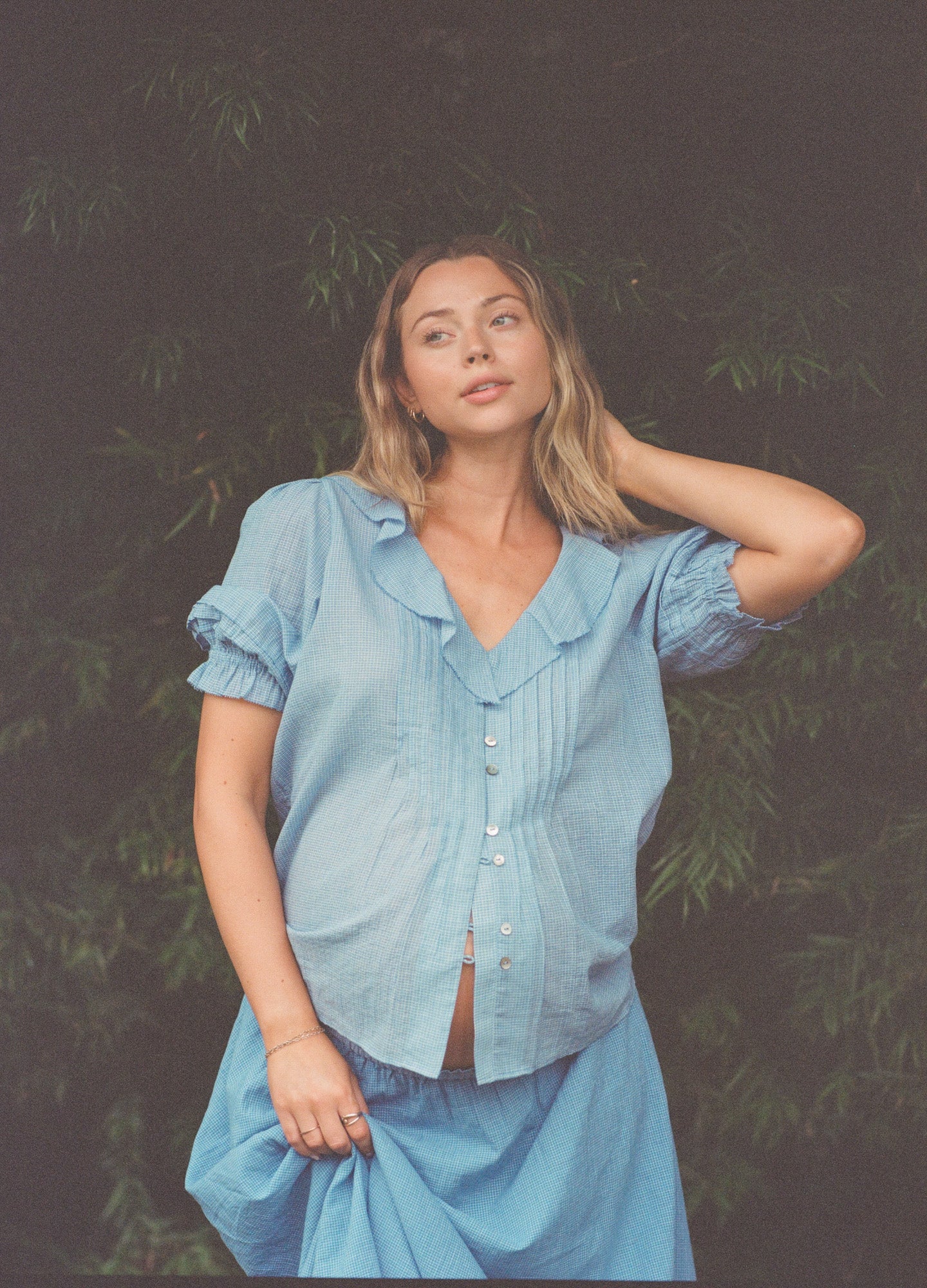 Light blue short-sleeve maternity blouse with front buttons and subtle puffed sleeves.
