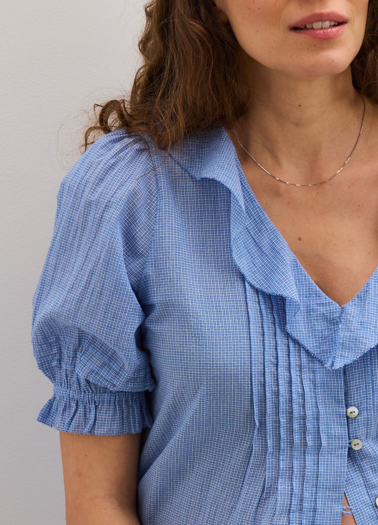 Light blue maternity nursing blouse with puff sleeves, ruffled collar, and front button detail.