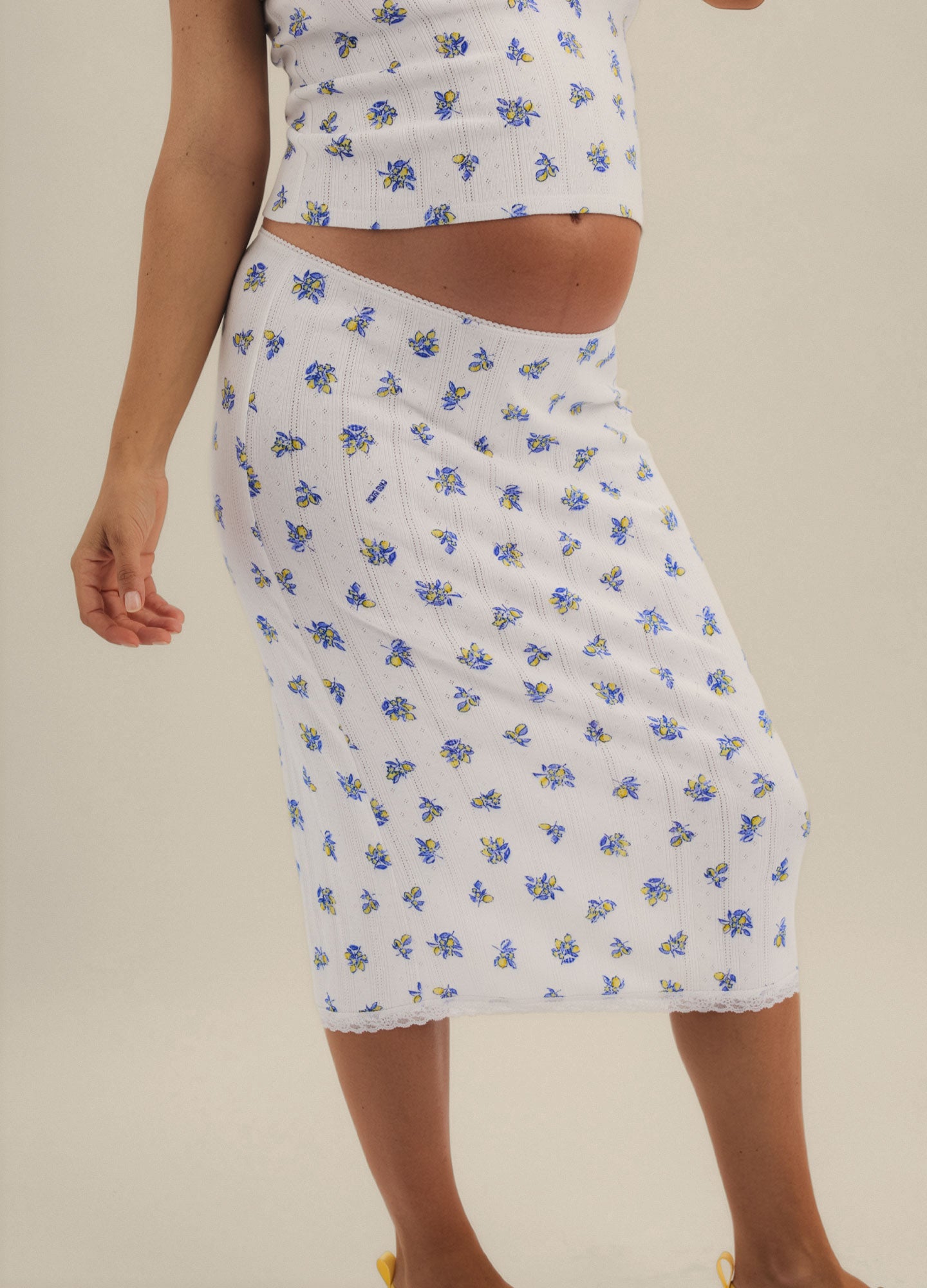White midi maternity skirt with blue floral pointelle knit and stretchy high waistband.