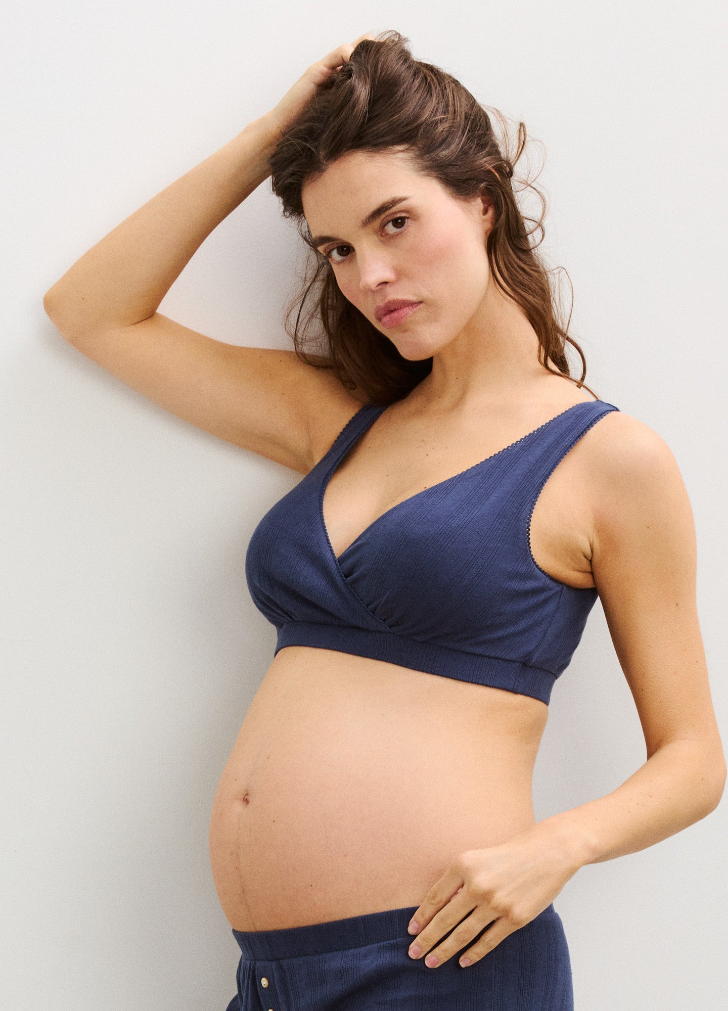Navy blue soft knit maternity bra with wide straps and a wrap-style front designed for nursing and comfort.