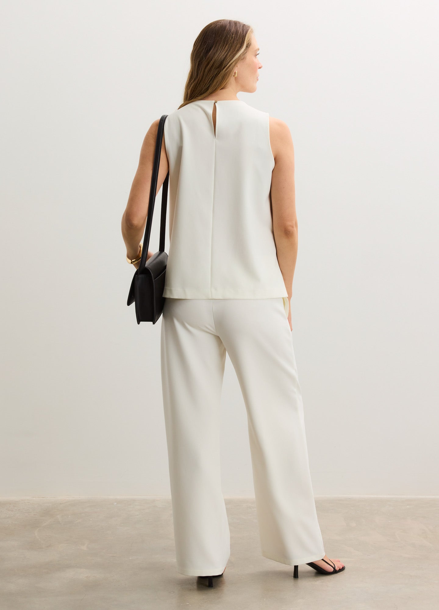 Cream sleeveless nursing tank with a subtle seam detail, paired with matching wide-leg pants.