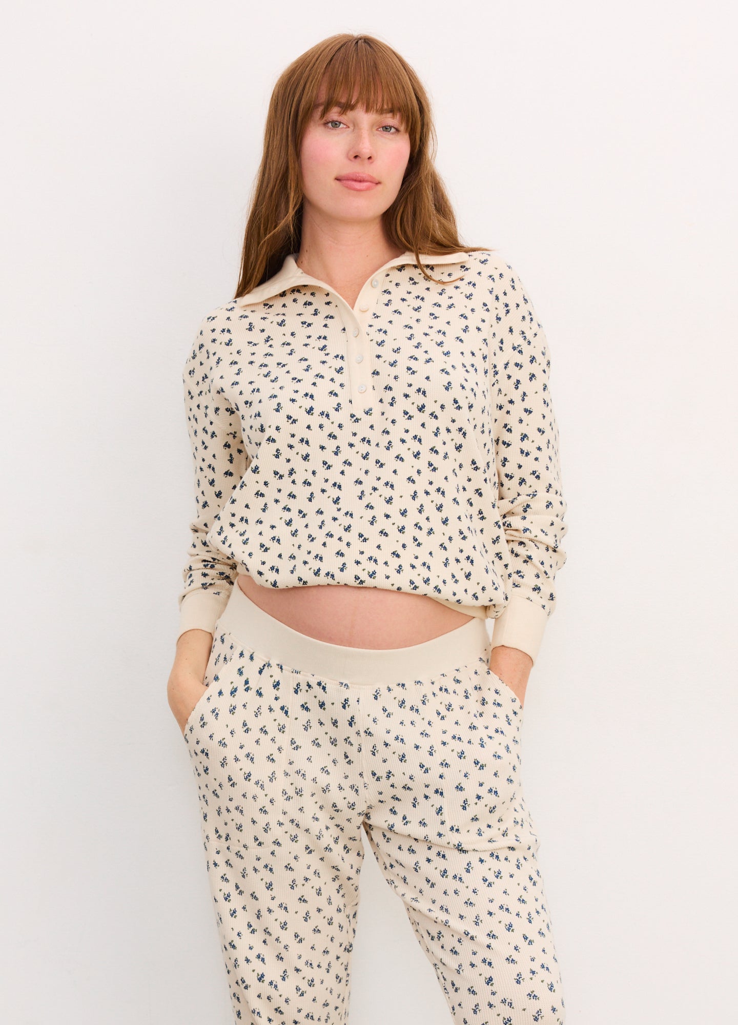 Cream waffle knit maternity pullover with black abstract print, quarter zip, and relaxed fit.
