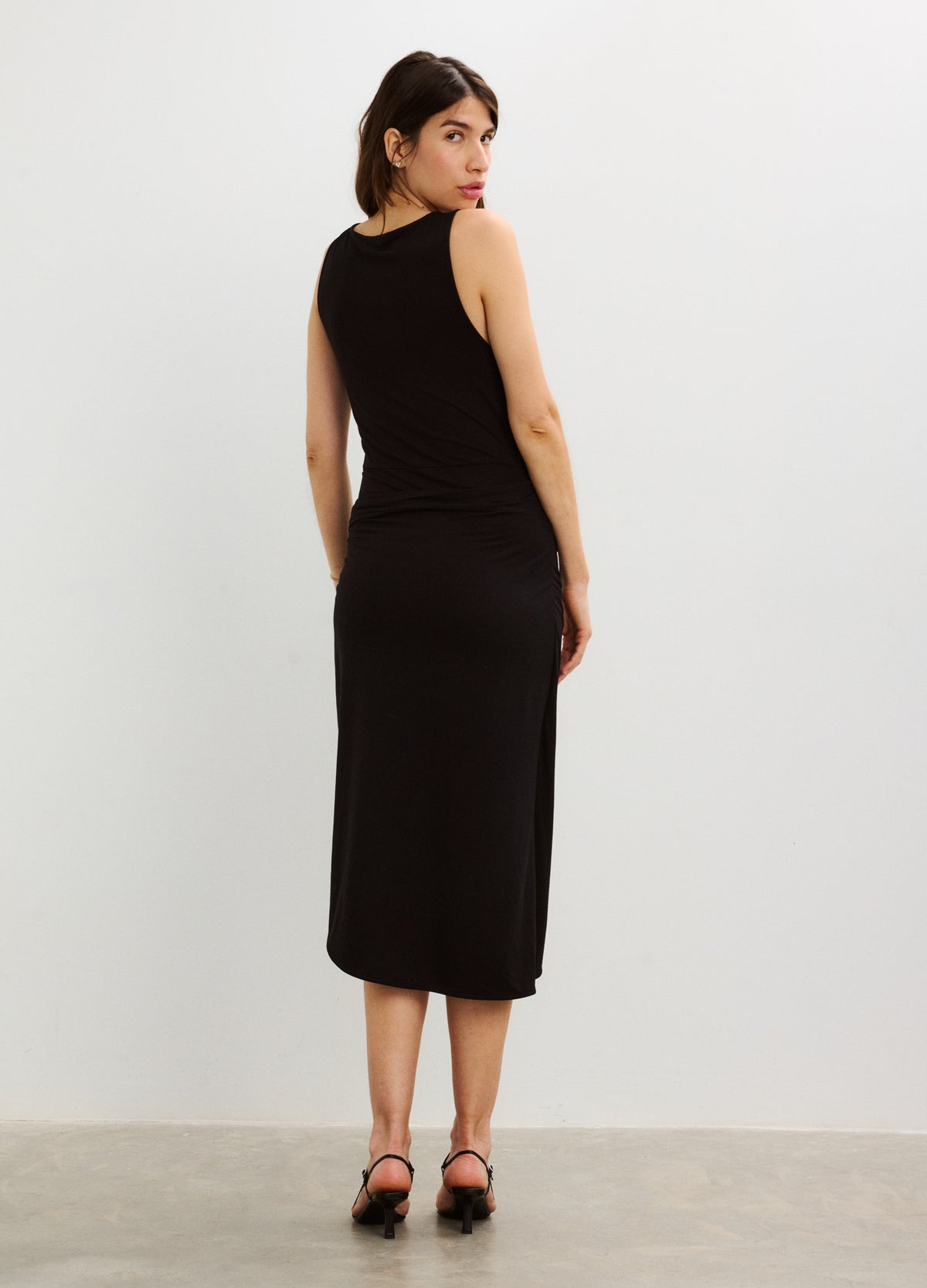 Black sleeveless midi wrap dress with a fitted silhouette designed for maternity wear.