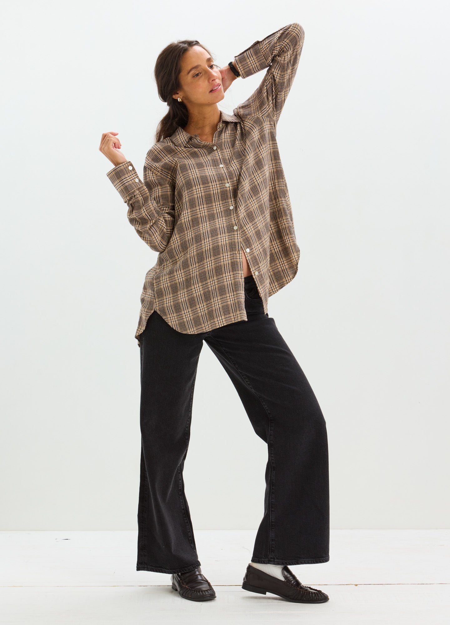 Black wide-leg maternity jeans with relaxed fit and stretchy waistband, styled with brown plaid shirt.