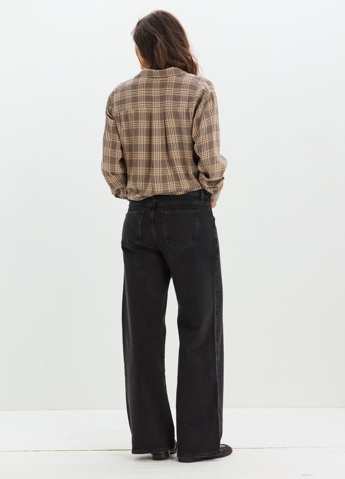 Black wide-leg maternity jeans with relaxed fit and full-length cut, worn by pregnant model seen from back.