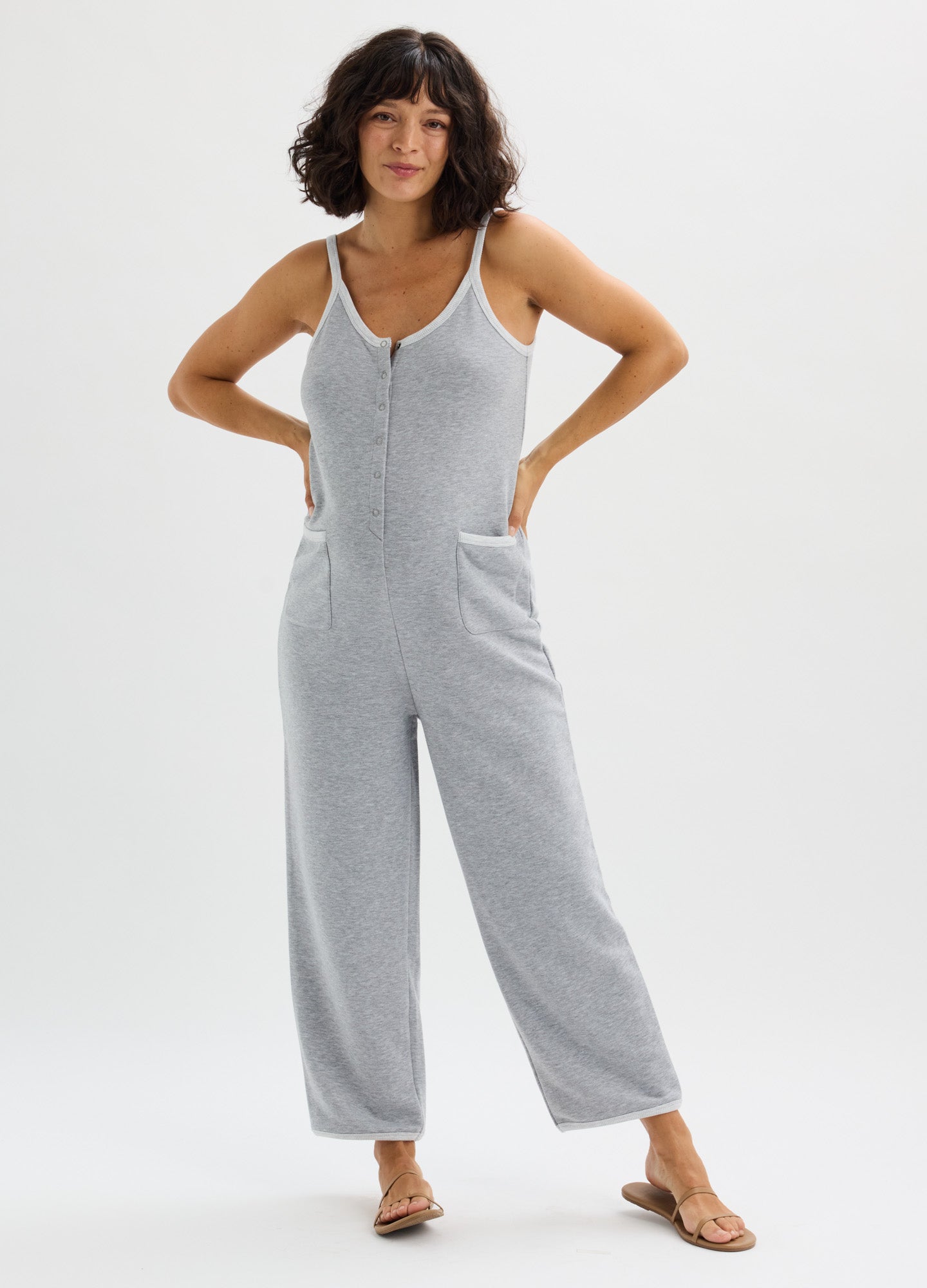 Light gray sleeveless maternity onesie with front zipper and wide legs, soft knit fabric.