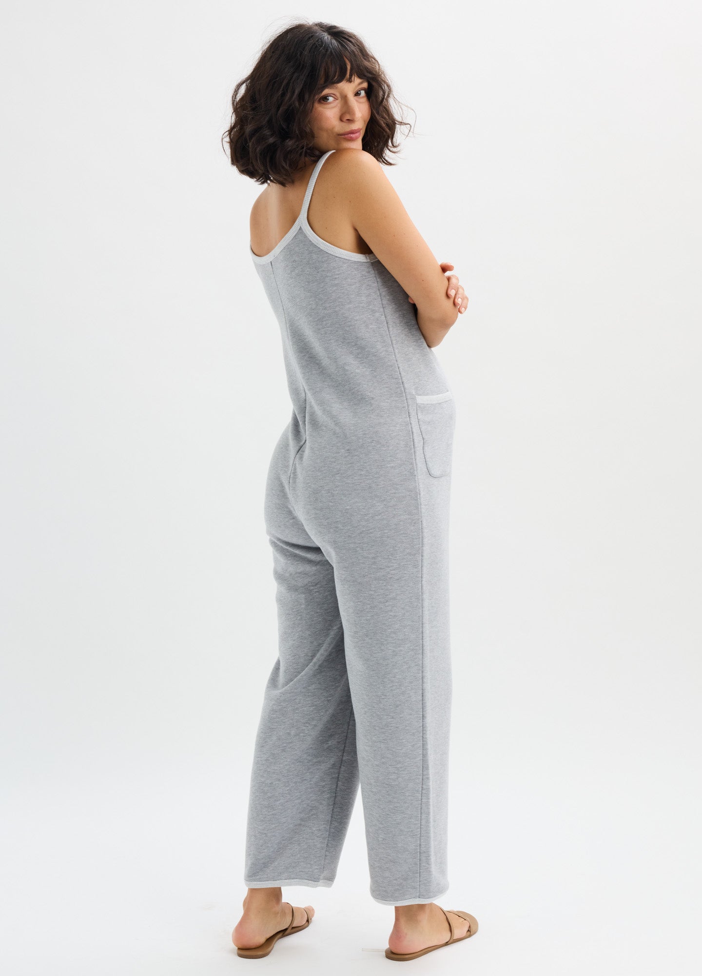 Light gray sleeveless maternity onesie with wide-leg pants and side pockets, soft fabric.