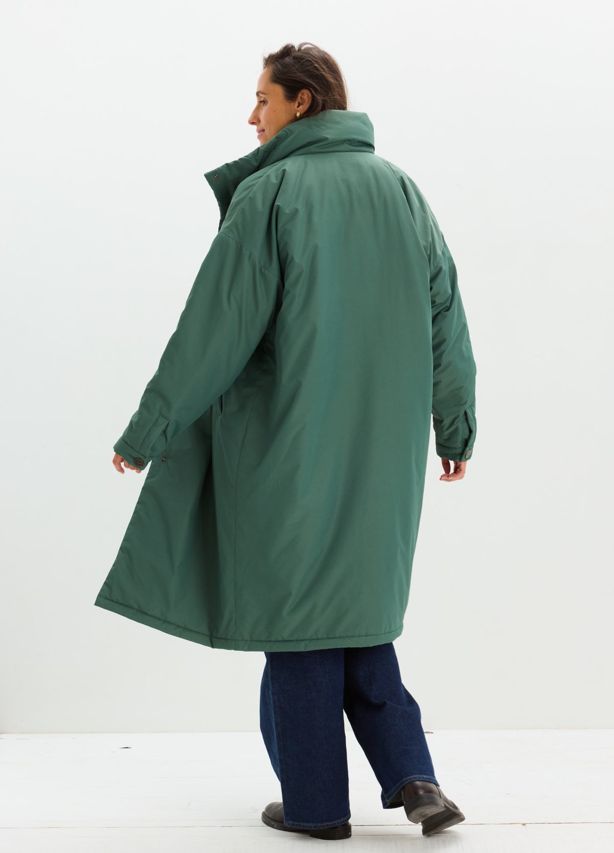 Long dark green padded coat with a high collar, loose fit, and below-knee length.