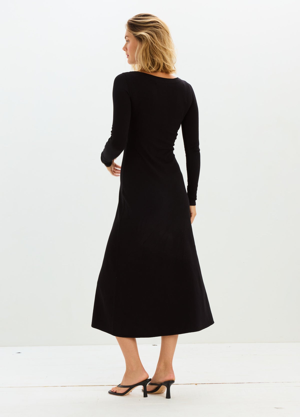 Black long-sleeve knit midi dress with fitted bodice and flared skirt, designed for maternity.