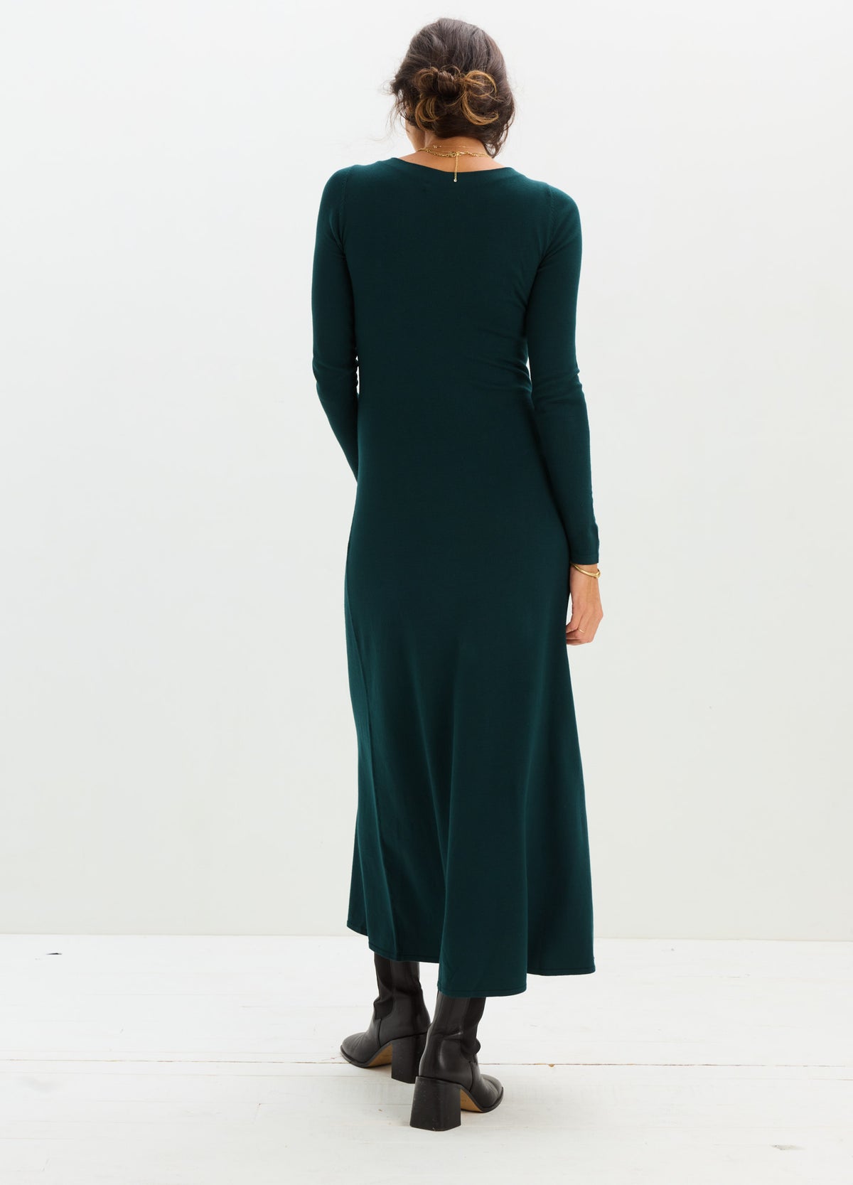 Dark green knit maternity dress with long sleeves and a flowing ankle-length skirt.