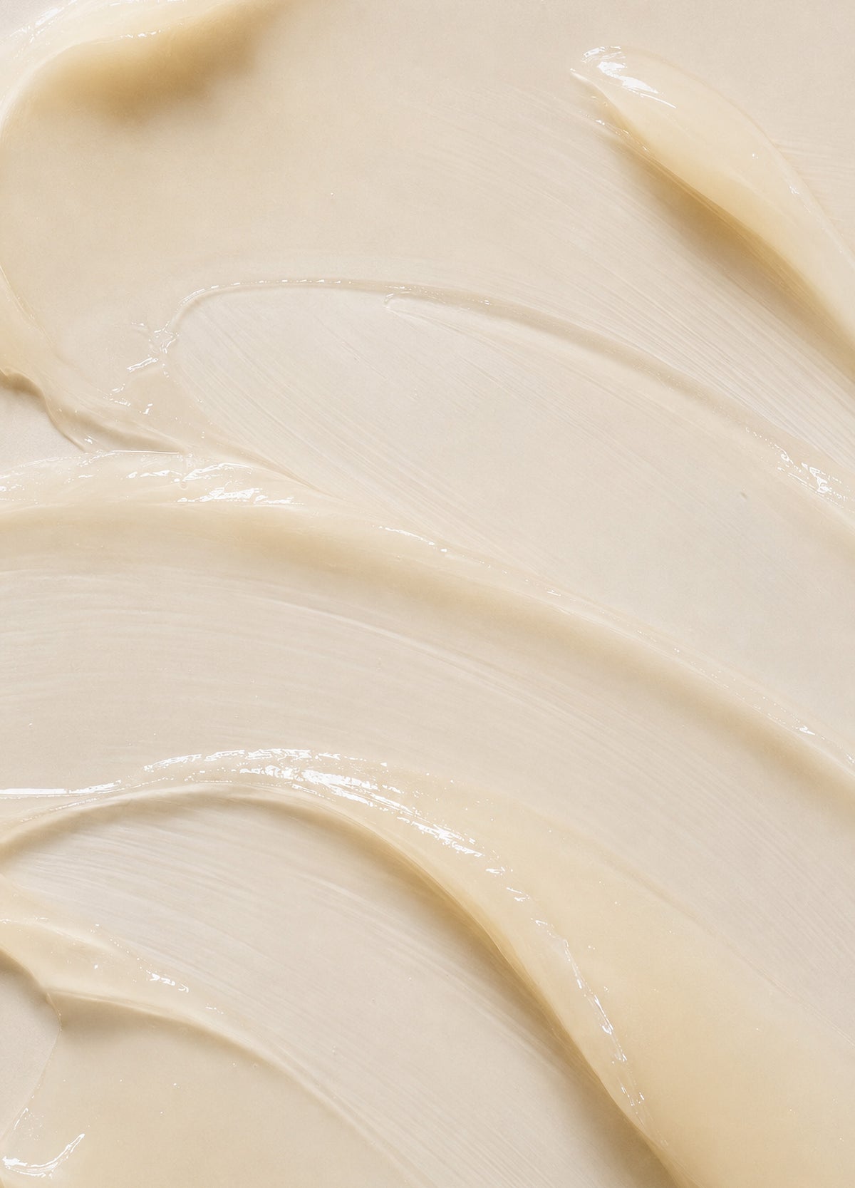 Smooth creamy beige balm texture with a glossy, rich consistency spread evenly.