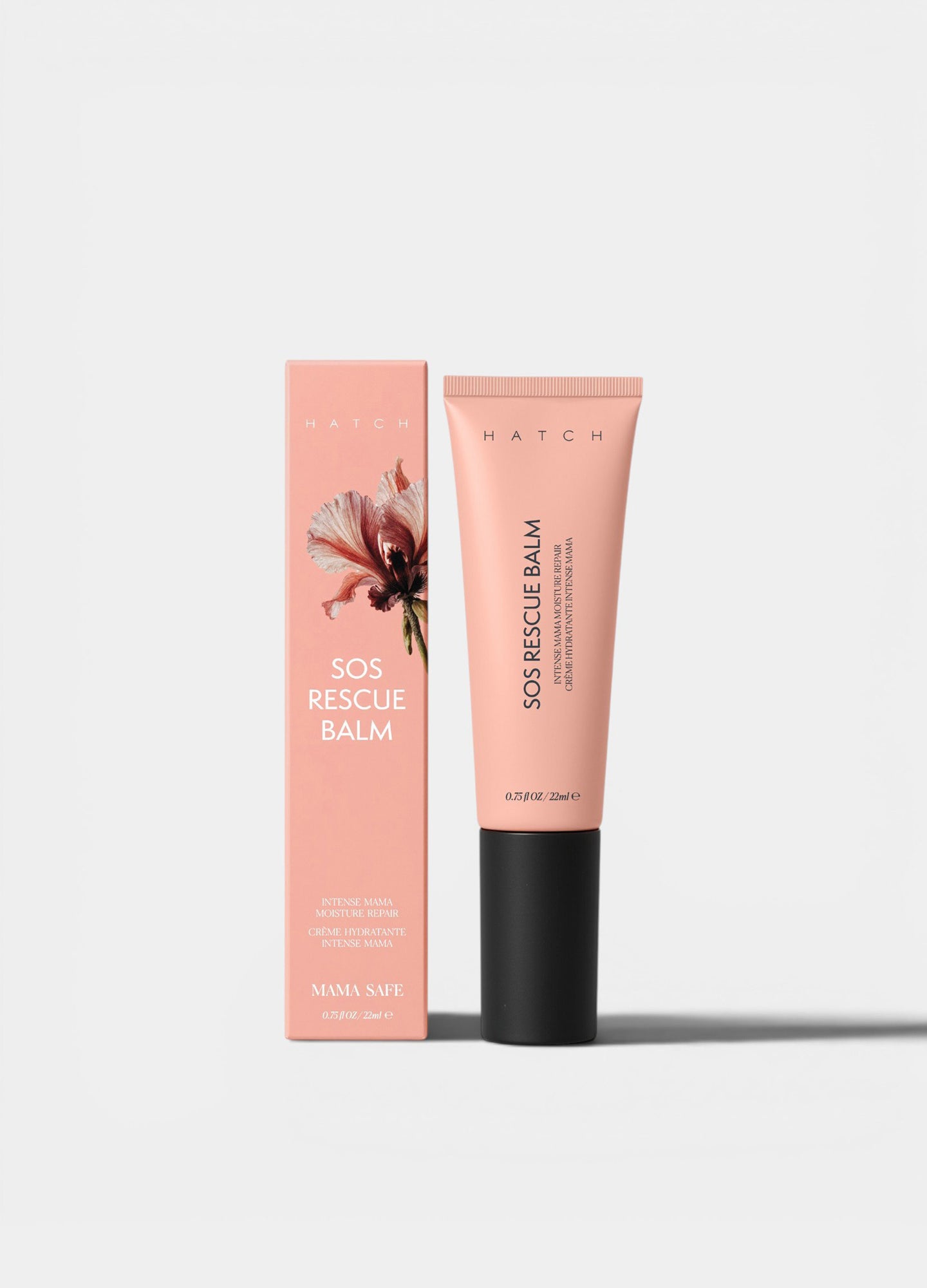 Peach-toned SOS Rescue Balm tube with black cap beside matching box featuring floral design, maternity skincare.