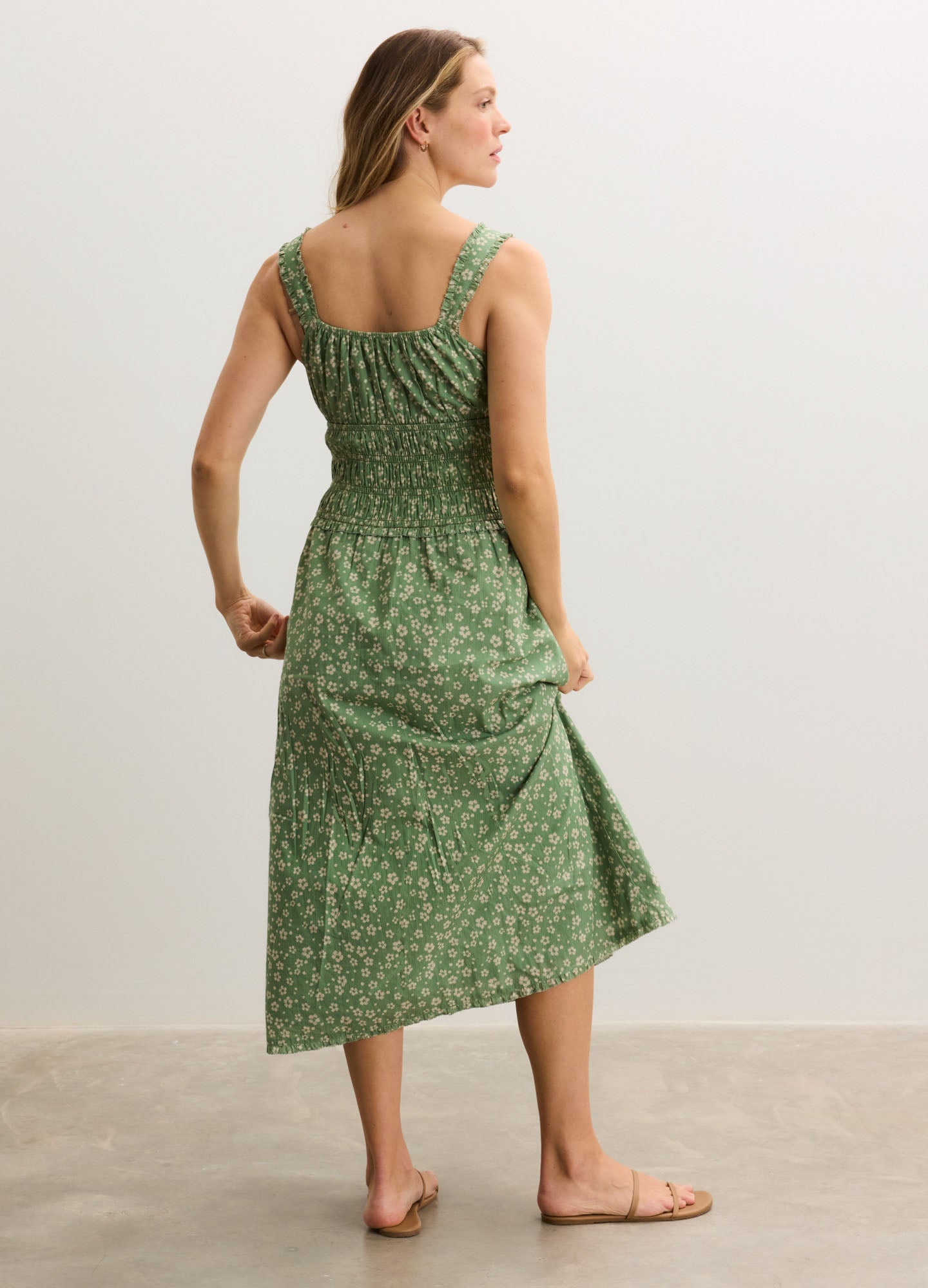 Green floral maternity dress with smocked back, wide straps, and midi length.