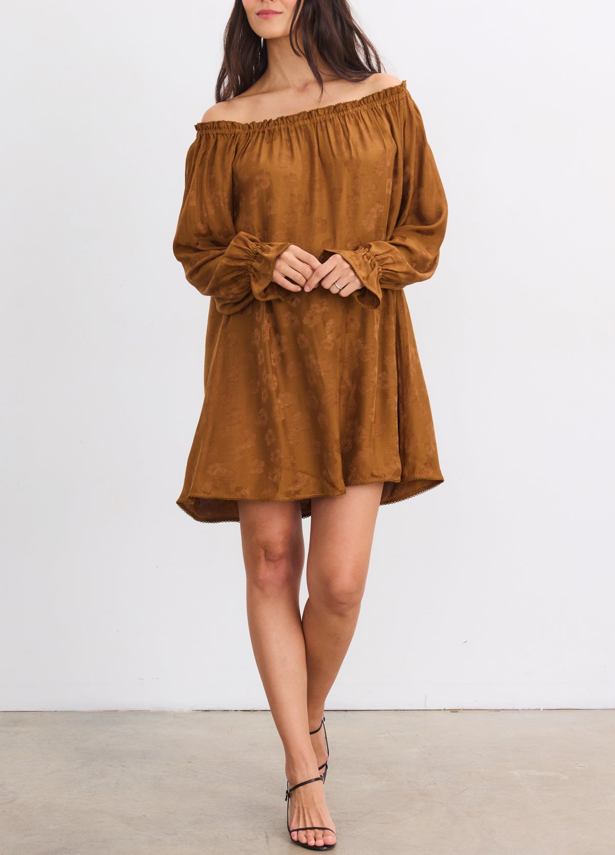 Rust-colored off-the-shoulder jacquard mini dress with long sleeves and loose, flowy fit designed for maternity.