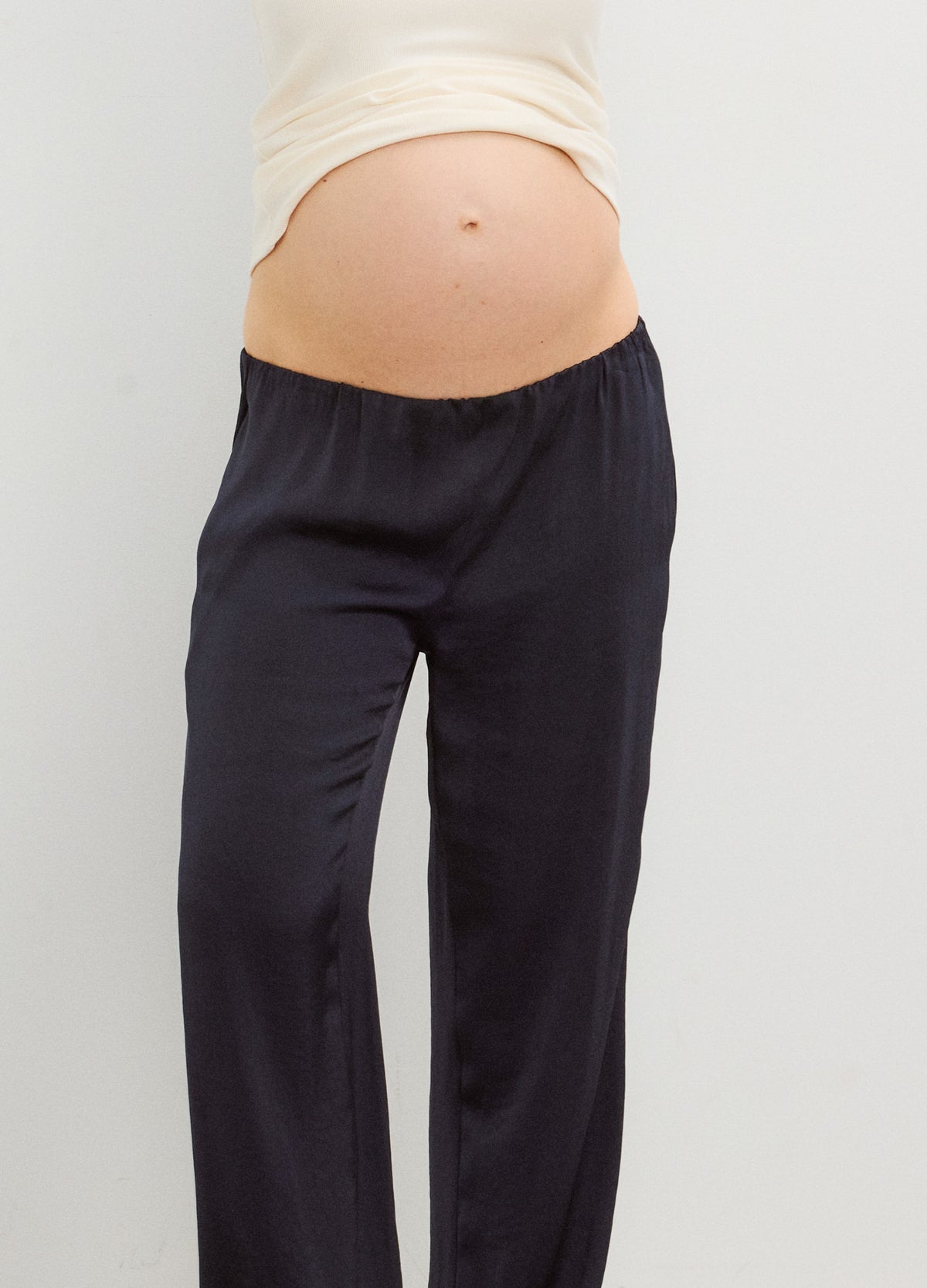 Black satin maternity pants with a high stretchy waistband, relaxed straight legs.