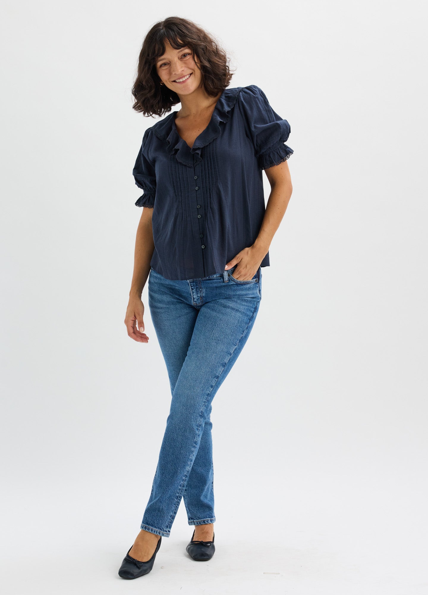 Blue slim-fit maternity jeans with stretchy waistband paired with navy short-sleeve blouse.