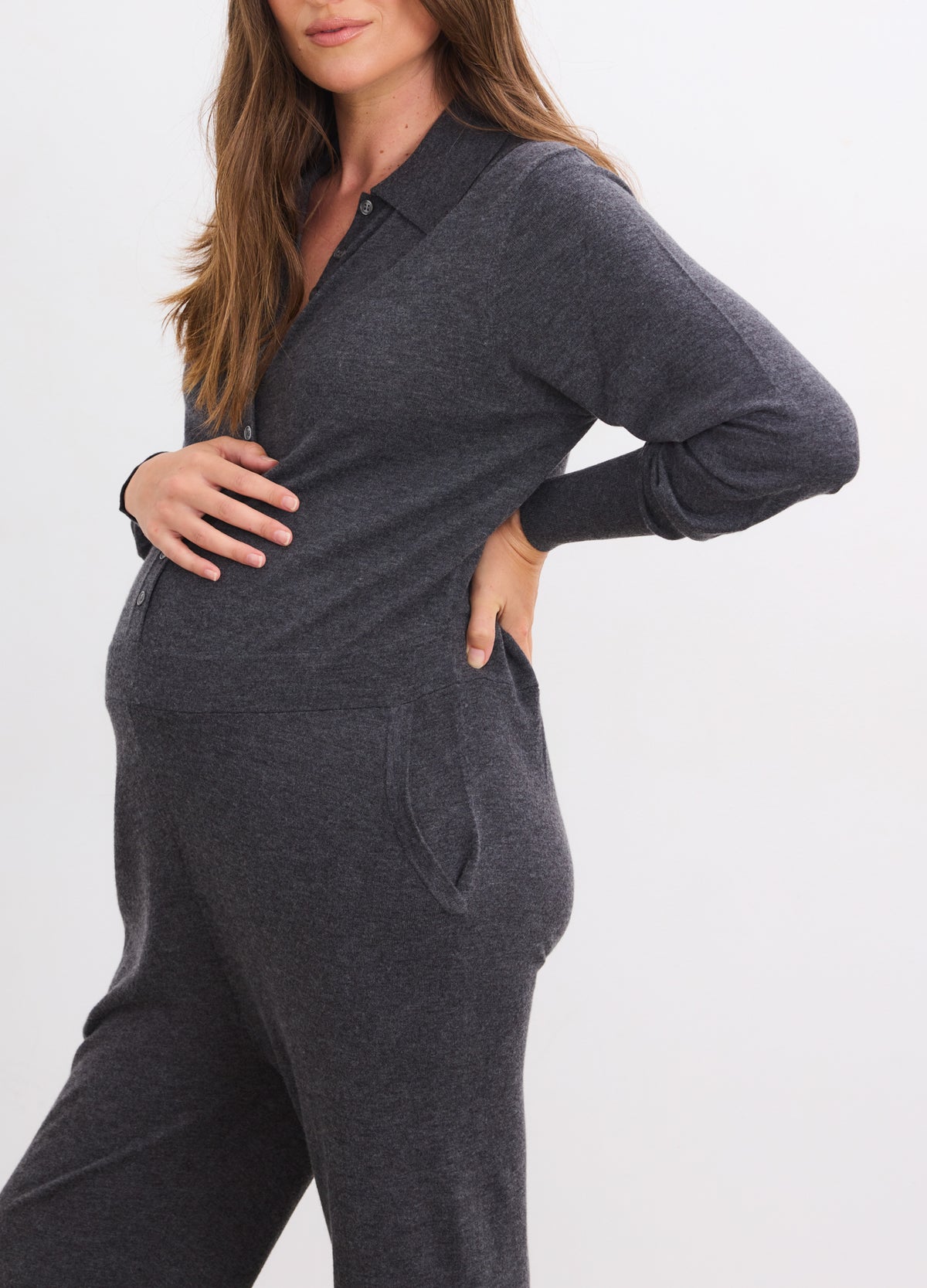 Charcoal melange soft knit maternity jumpsuit with long sleeves and collar, worn by pregnant woman.