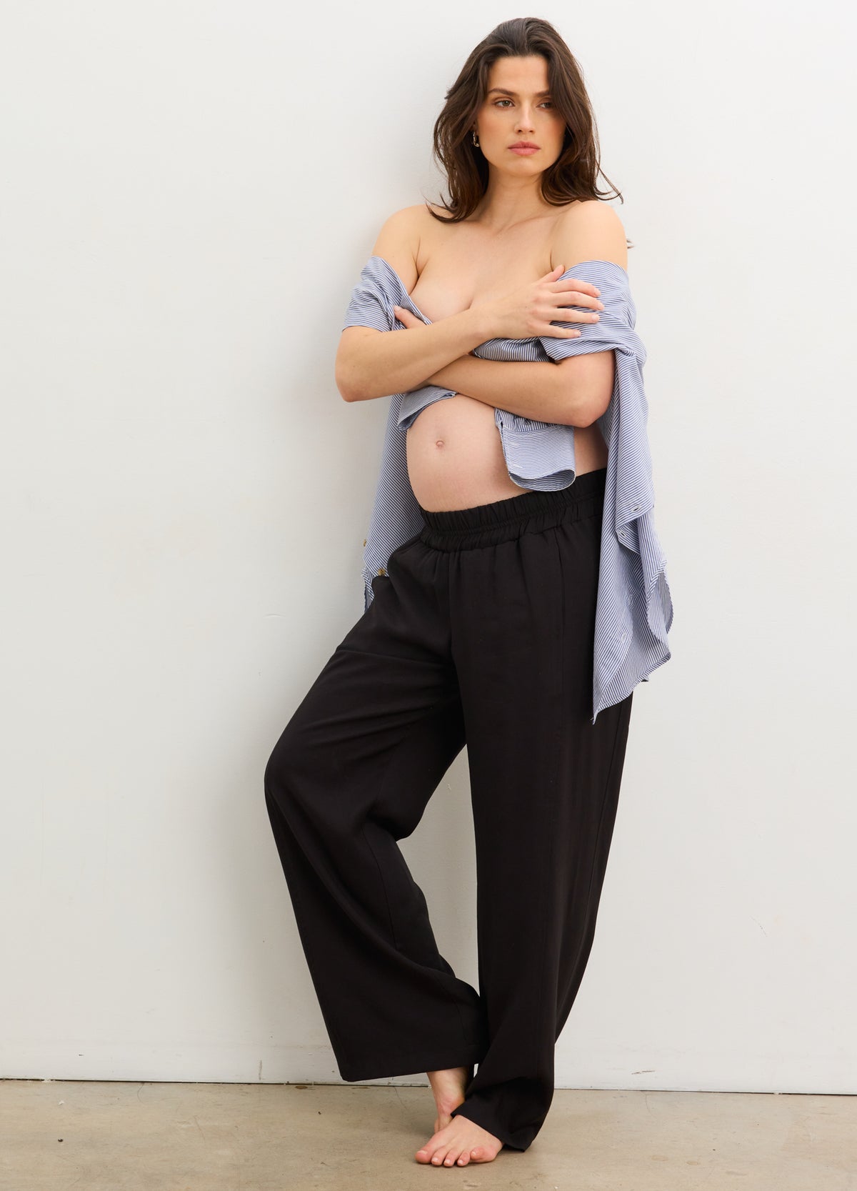 The Soft Tailored Pull On Trouser - Black soft tailored maternity trousers with a pull-on waistband, styled with a blue nursing-friendly blouse and black blazer.