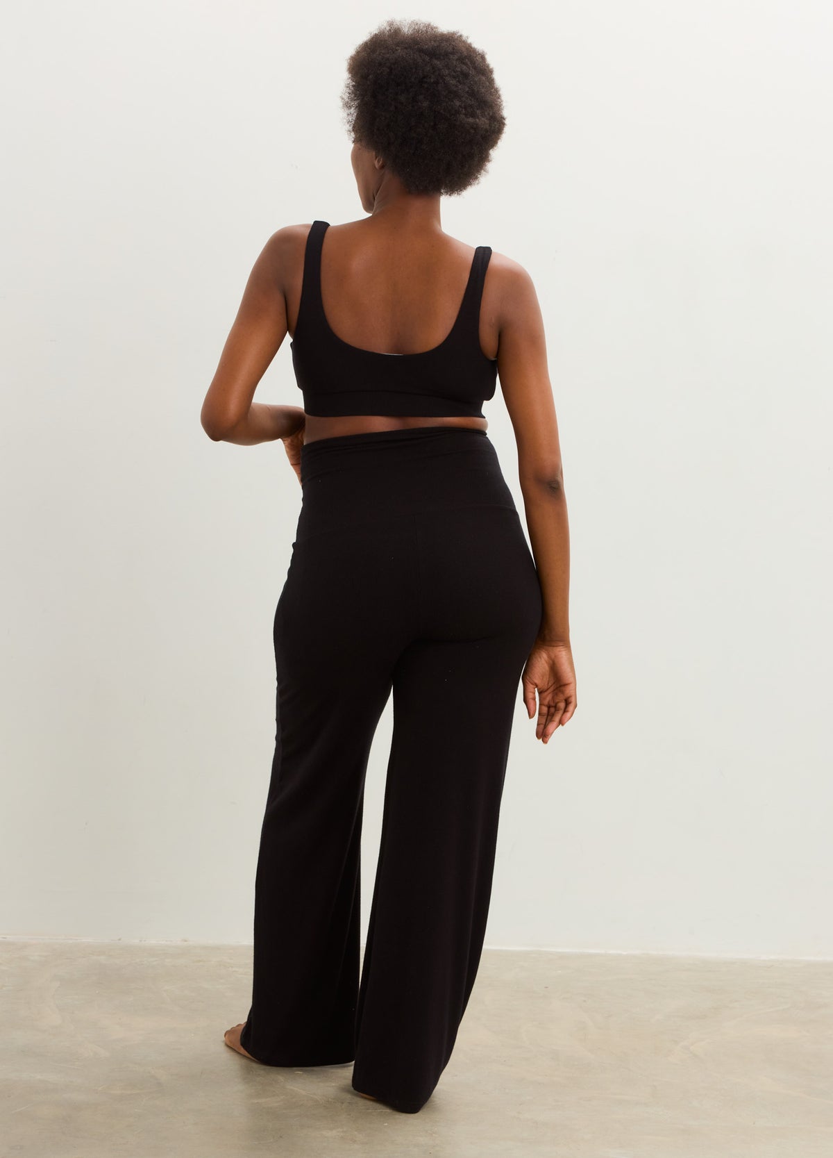 Black maternity jumpsuit with a scoop-back nursing bra top and relaxed wide-leg pants.