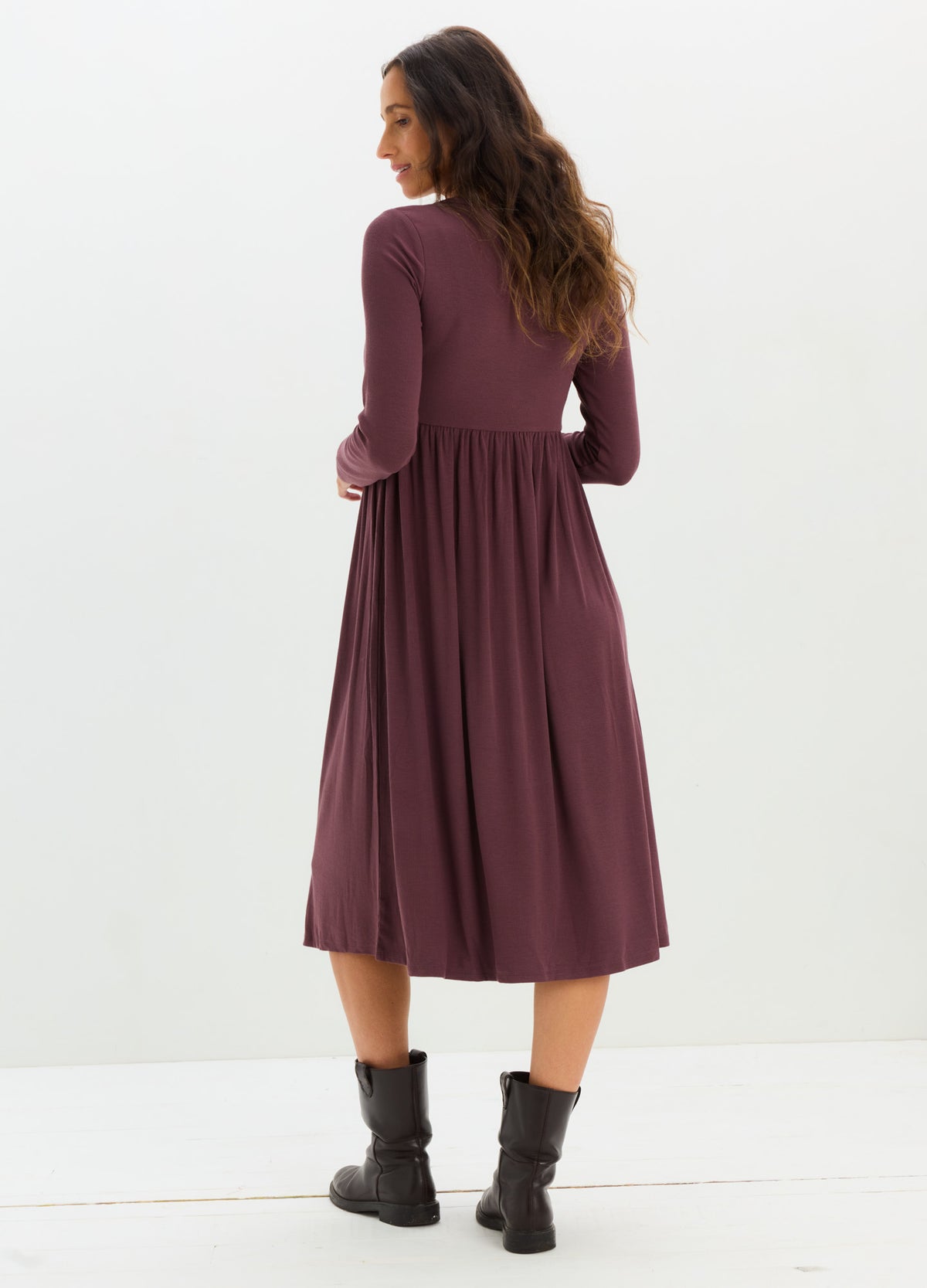 Mauve rib-knit midi nursing dress with long sleeves and gathered waist, worn with black ankle boots.
