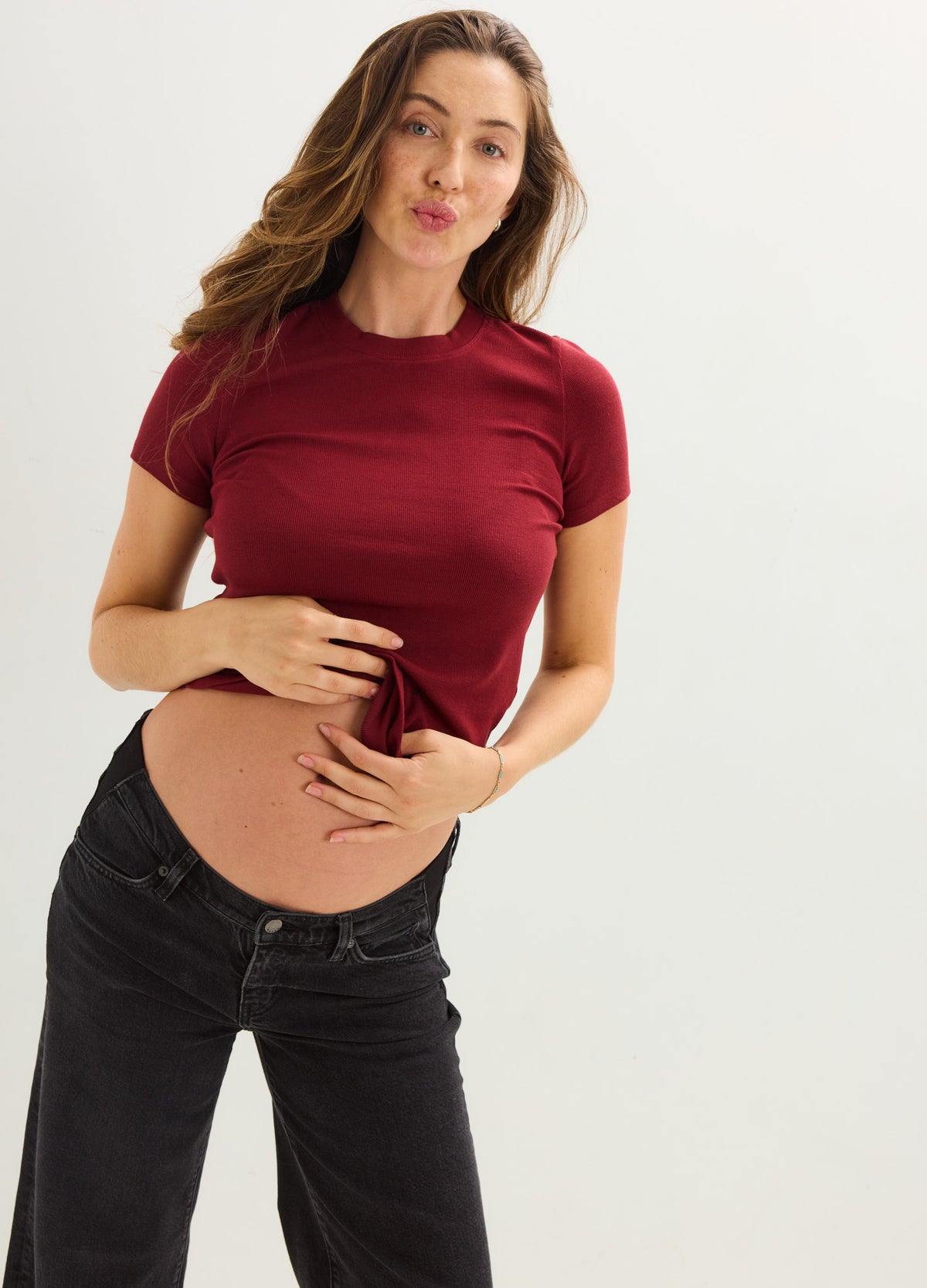 Burgundy ribbed short-sleeve maternity tee with stretchy, soft fabric designed for pregnant figures.