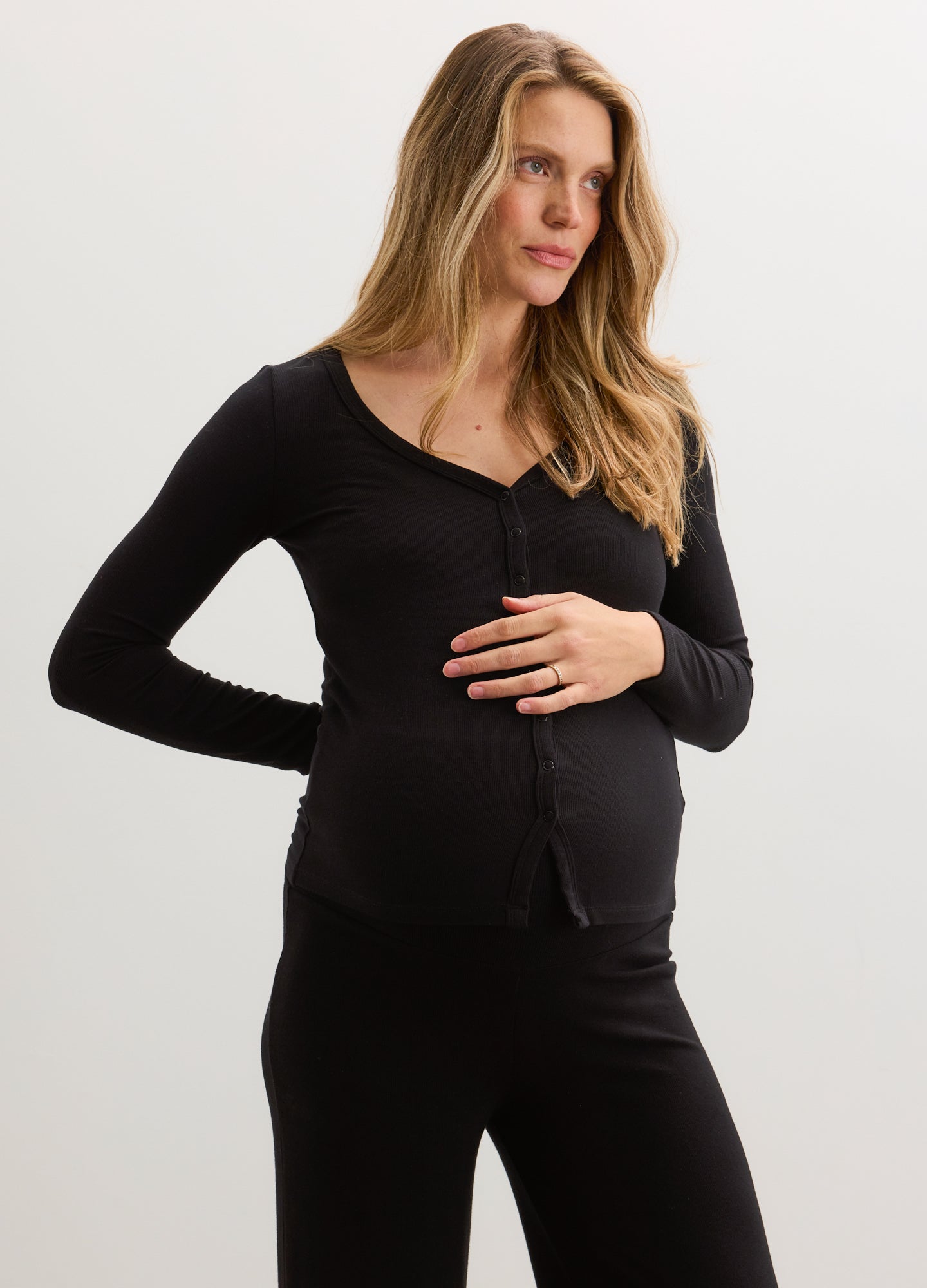 Black ribbed maternity nursing cardigan with long sleeves and button front, worn by pregnant woman.