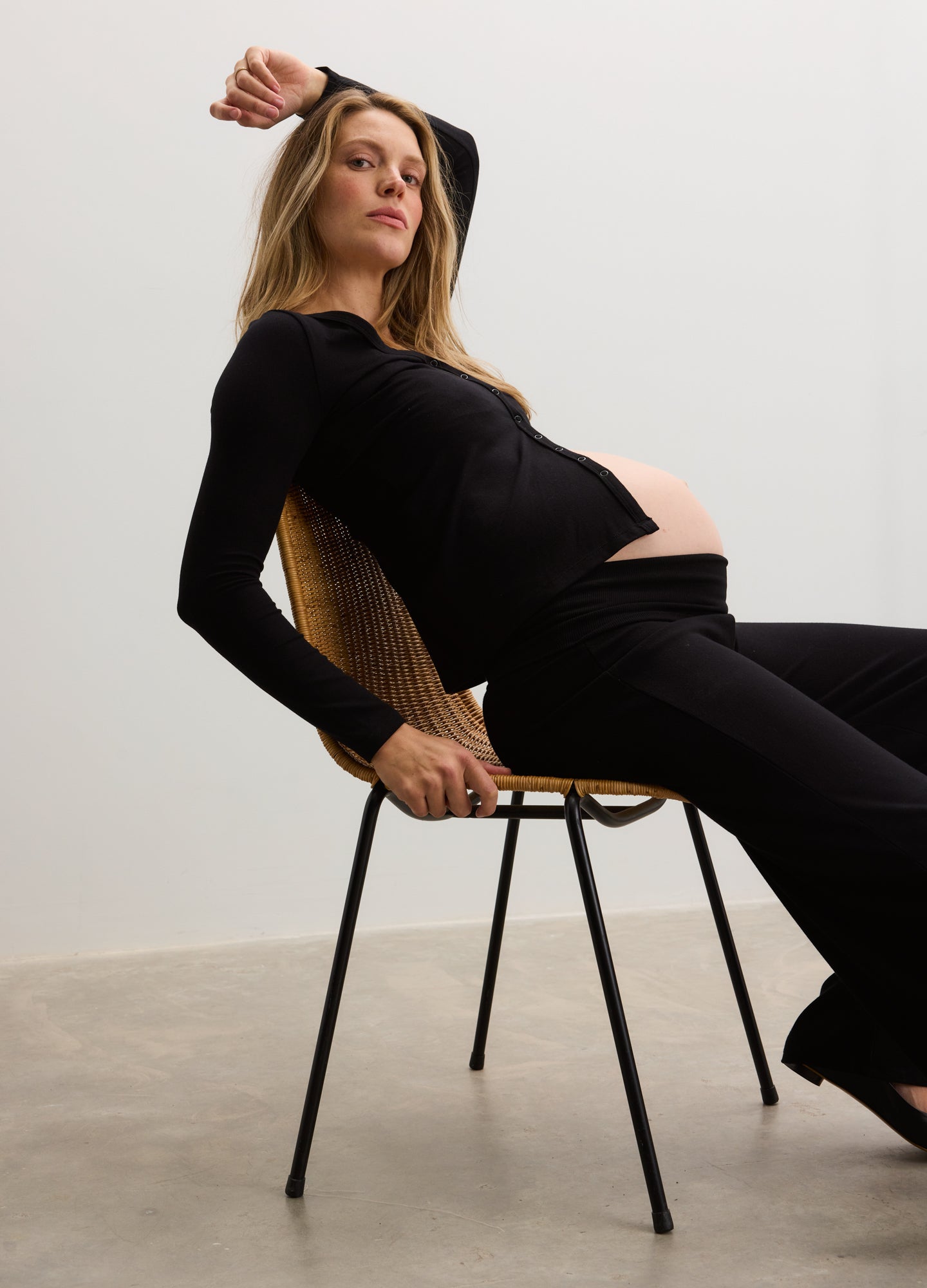 Black ribbed knit maternity nursing cardigan with long sleeves worn by pregnant woman.