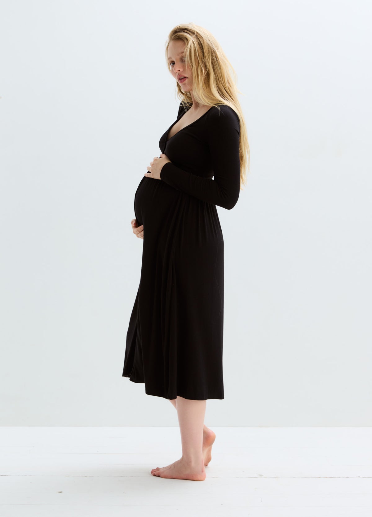 Black ribbed knit maternity nursing dress with long sleeves and a mid-calf length hem.