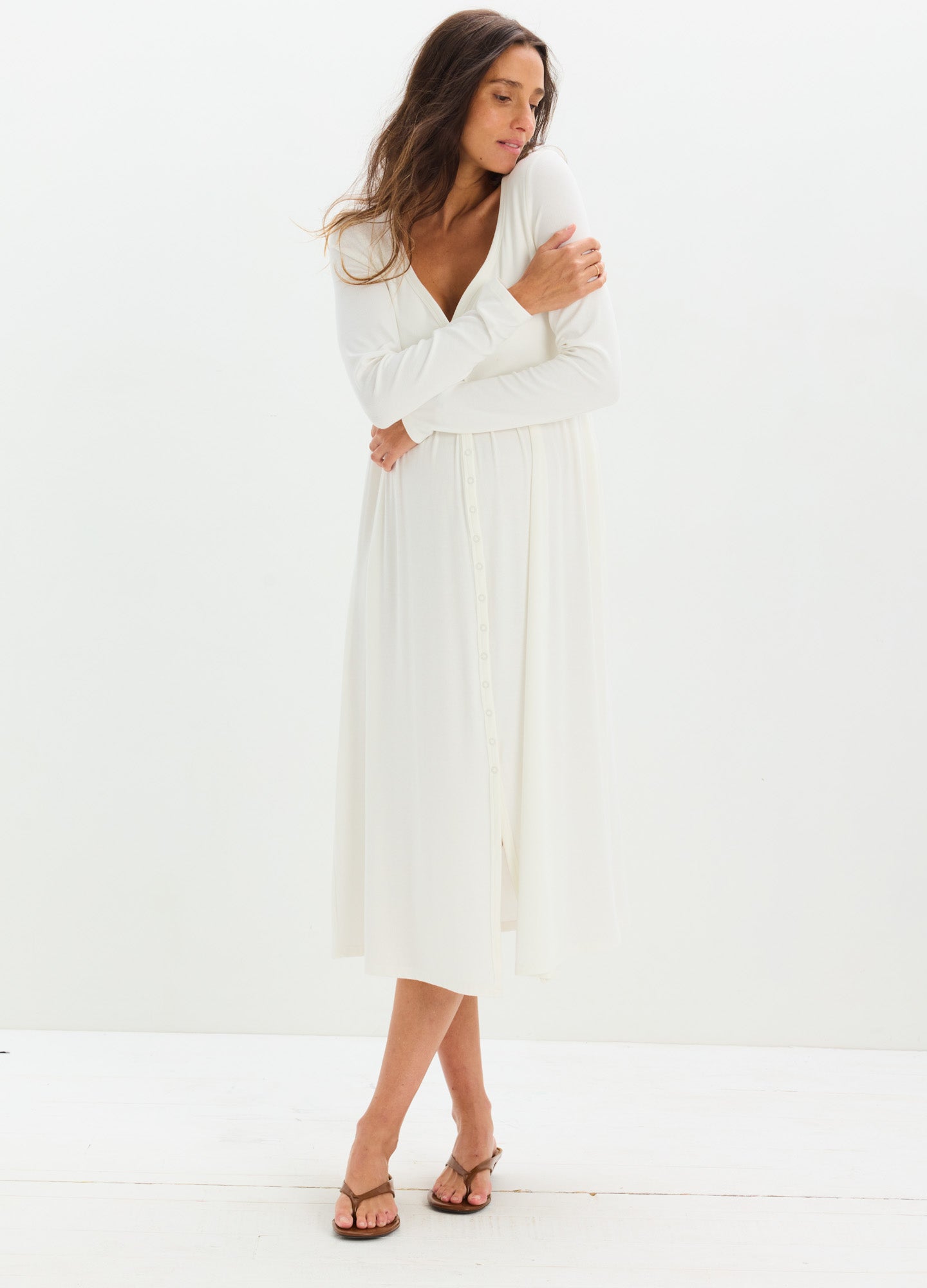 White long-sleeve ribbed maternity dress with a V-neck and midi length, soft fabric.