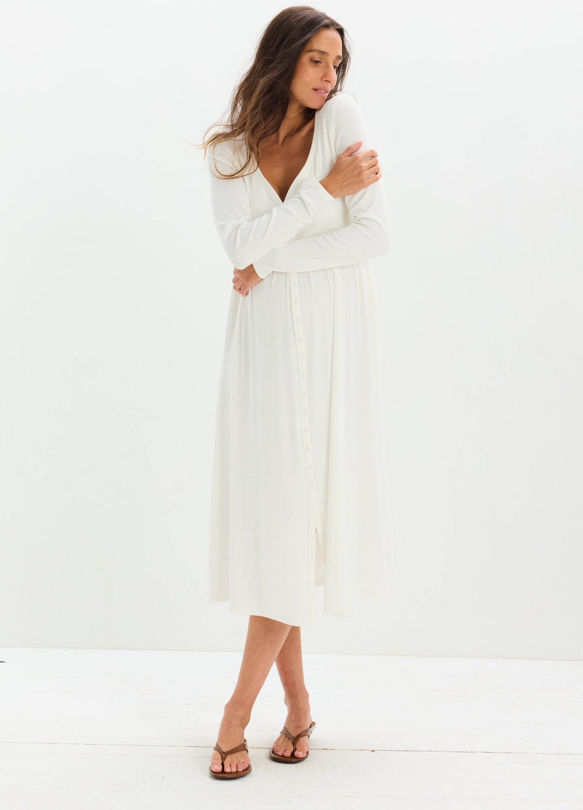White long-sleeve ribbed maternity dress with a V-neck and midi length, soft fabric.