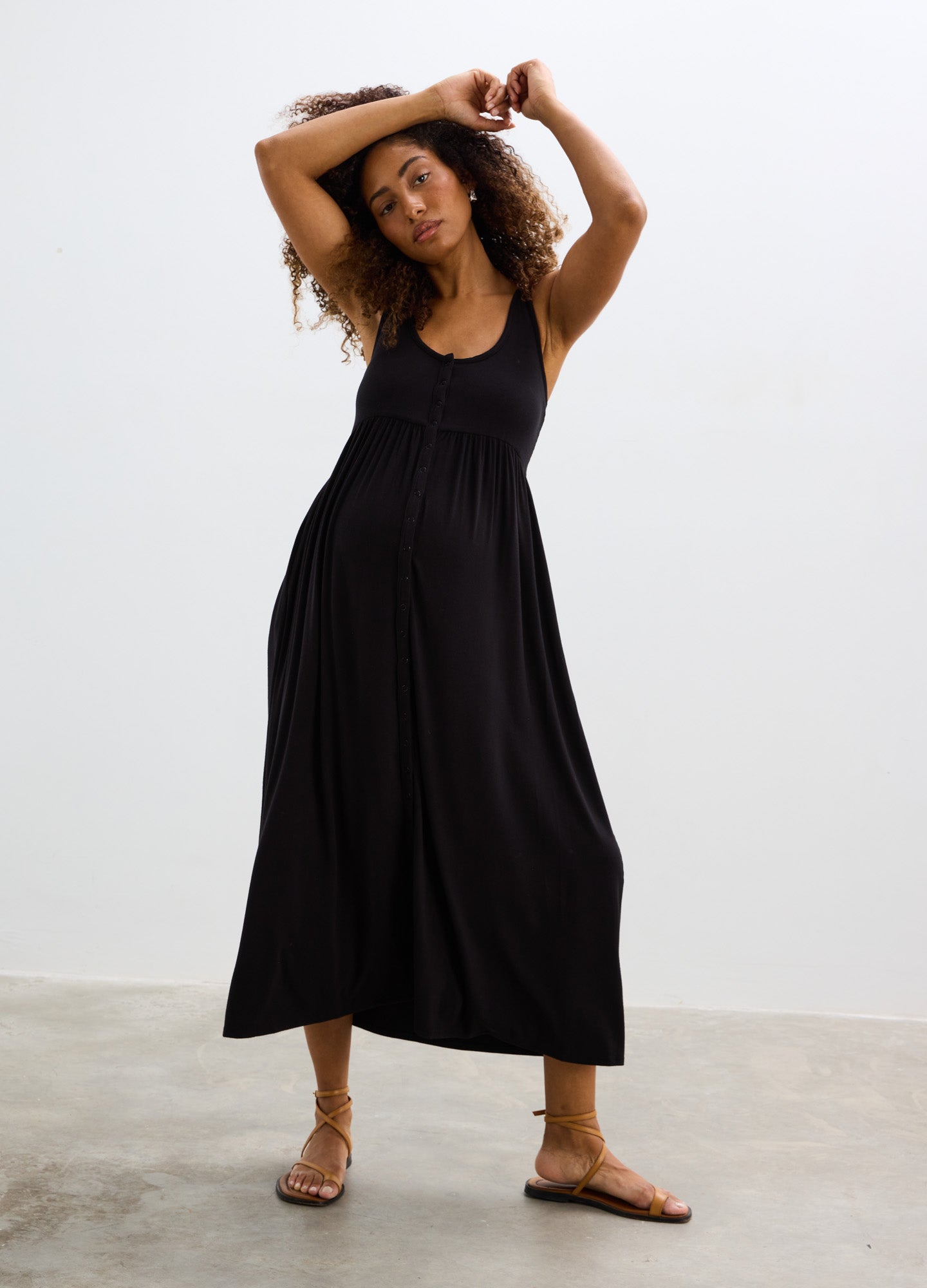 Black soft ribbed nursing tank dress with scoop neck and flowing midi skirt, styled for maternity wear.